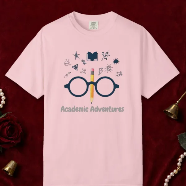 Academic Adventures design on a Blossom Comfort Colors 1717 tee, laid flat