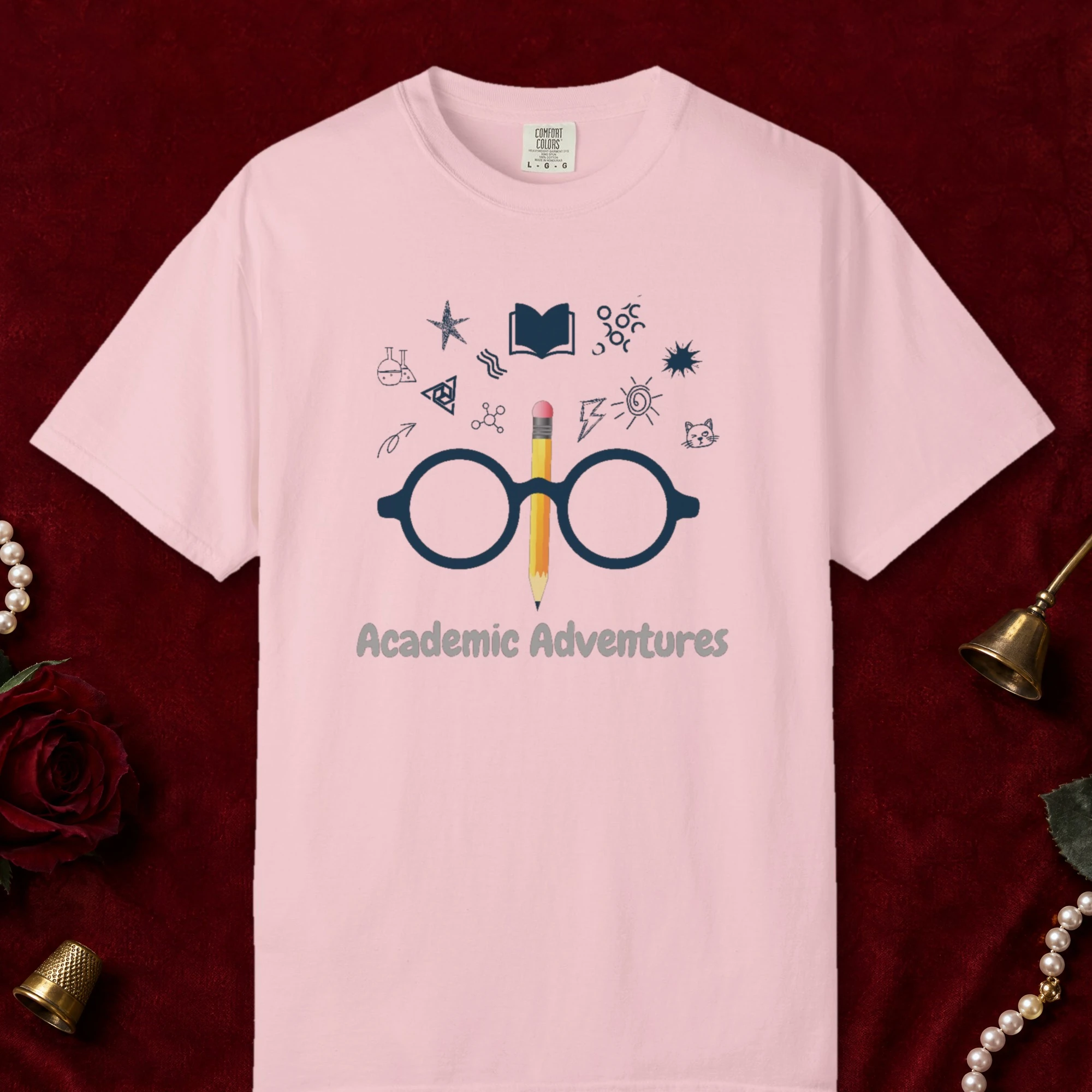 Academic Adventures design on a Blossom Comfort Colors 1717 tee, laid flat