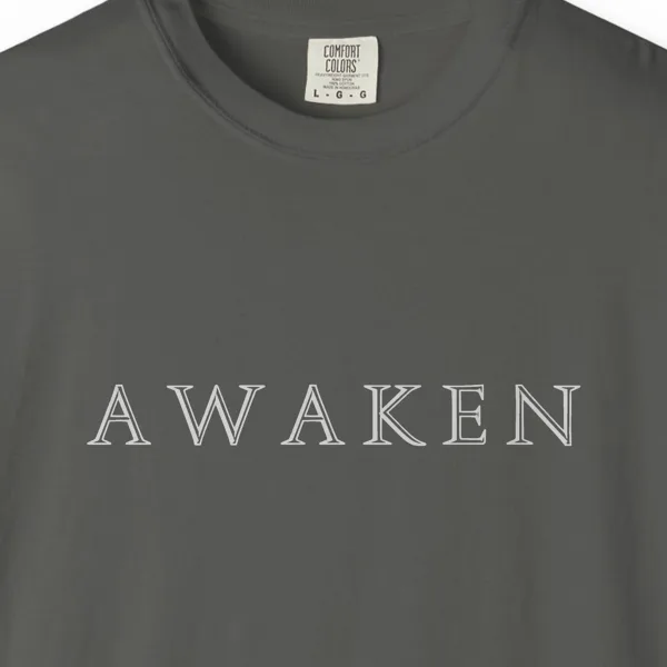 awaken-engraved-capitals-tee-pepper-chest Close-up of the Awaken Engraved Capitals print on a Pepper Comfort Colors 1717 tee