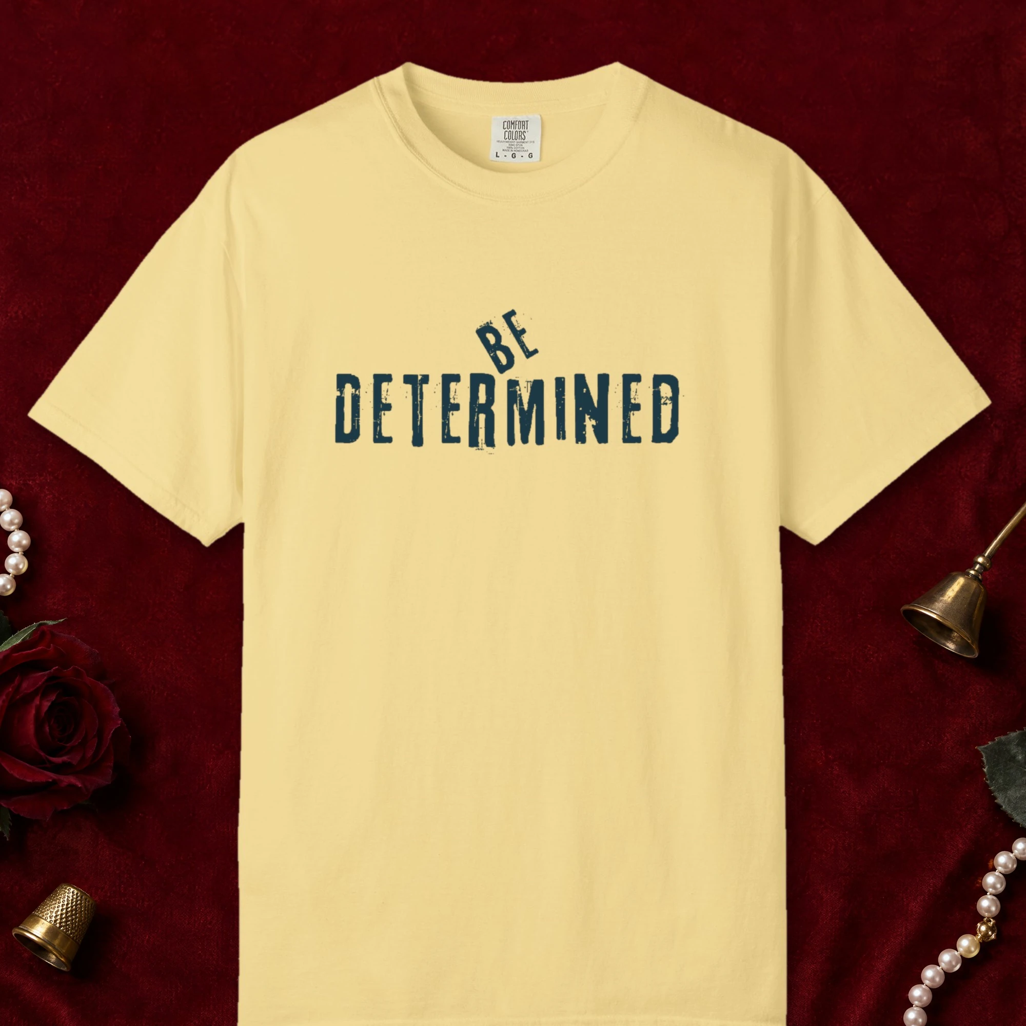 Be Determined design on a Butter Comfort Colors 1717 tee, laid flat