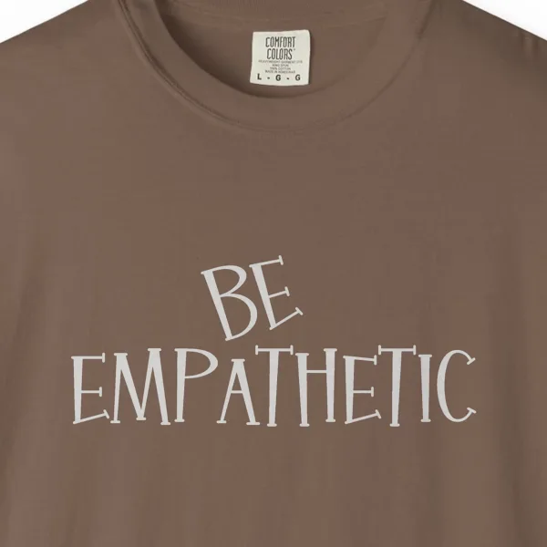 Close-up of the Be Empathetic print on a Espresso Comfort Colors 1717 tee