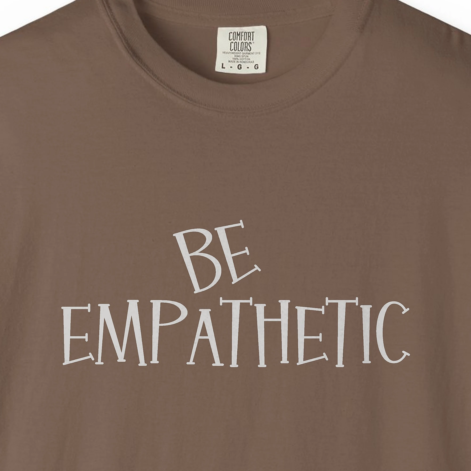 Close-up of the Be Empathetic print on a Espresso Comfort Colors 1717 tee