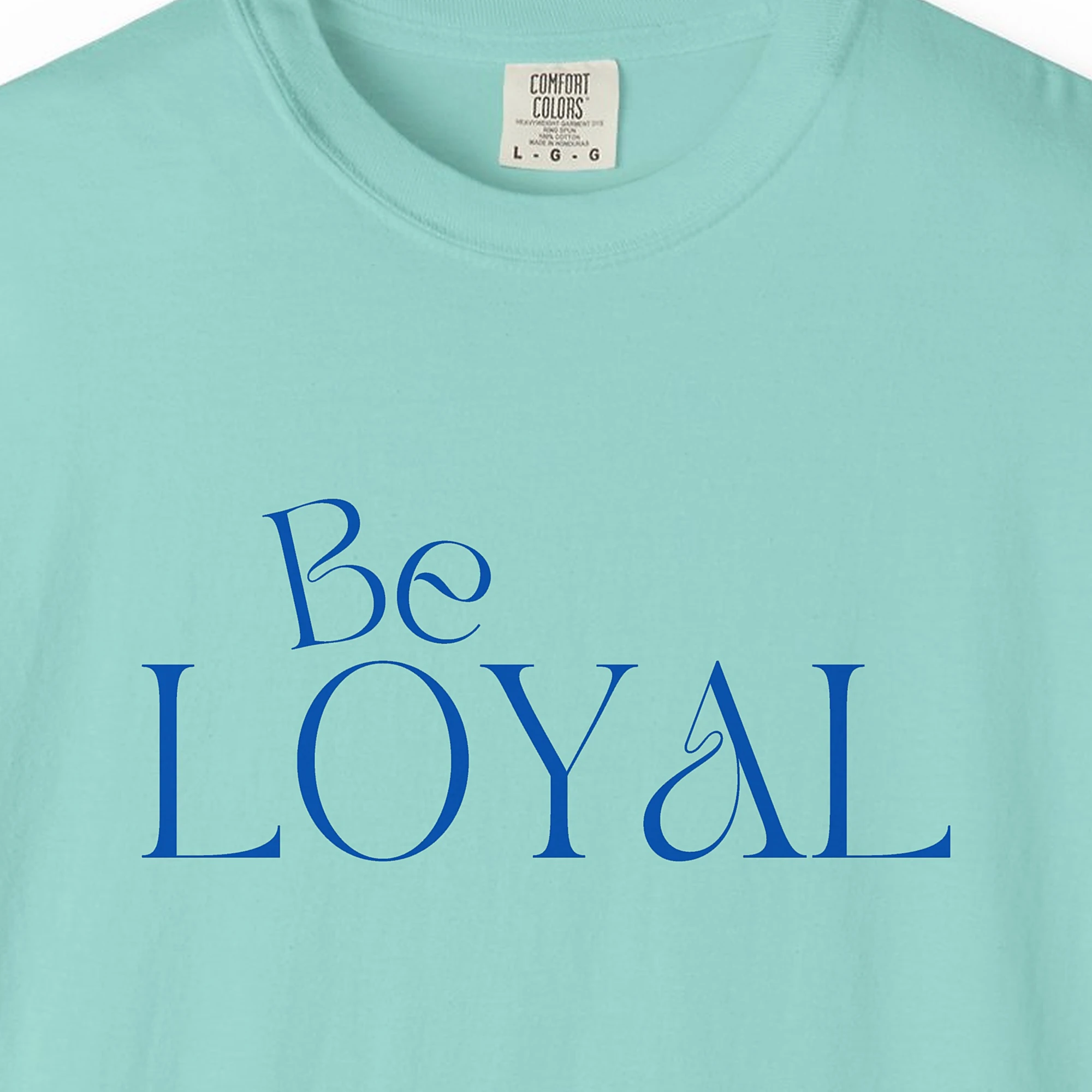Close-up of the Be Loyal print on a Chalky Mint Comfort Colors 1717 tee