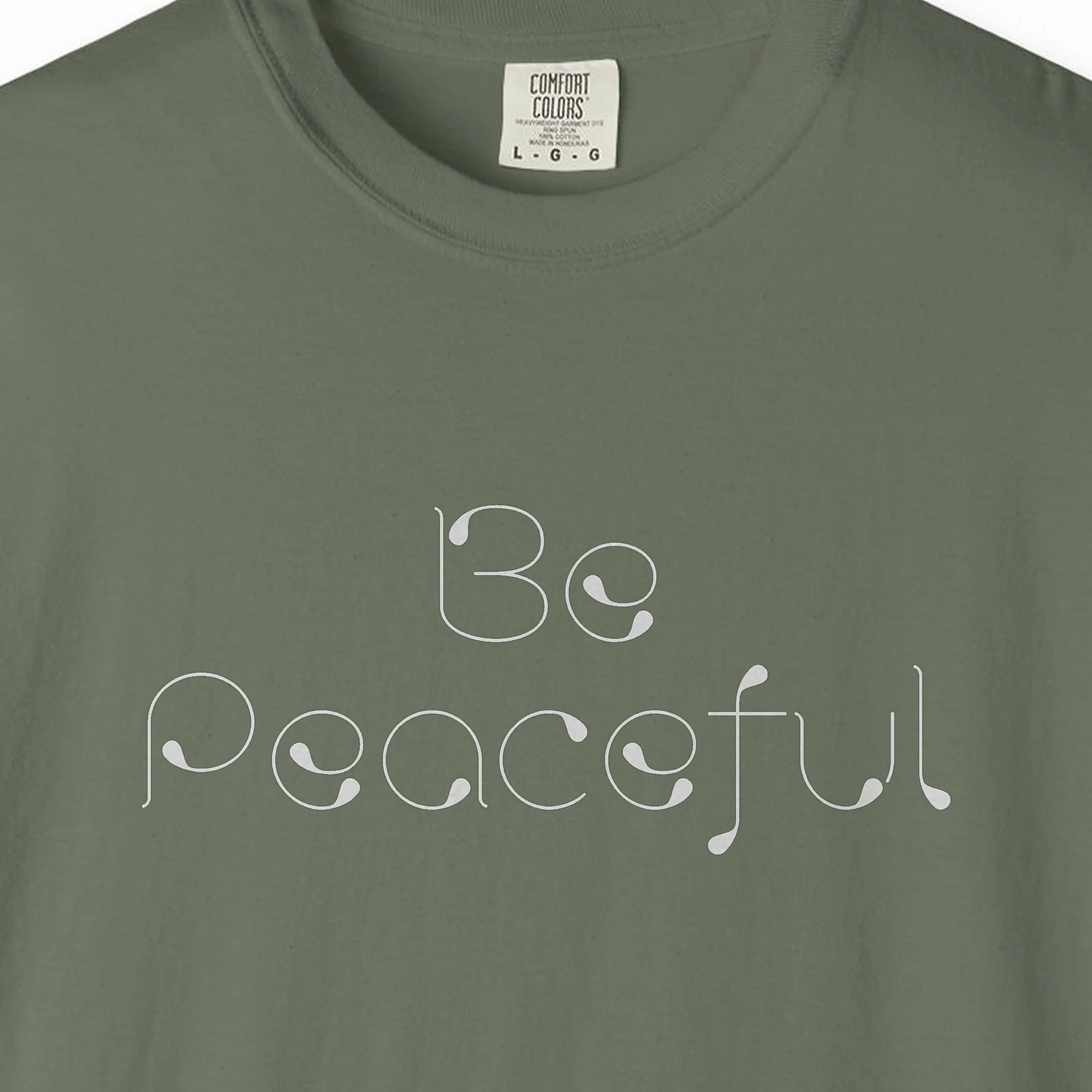 Close-up of the Be Peaceful print on a Moss Comfort Colors 1717 tee