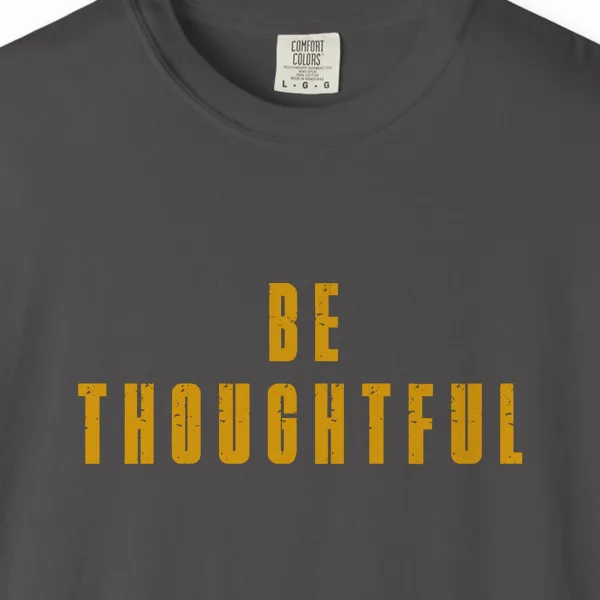 Close-up of the Be Thoughtful print on a Graphite Comfort Colors 1717 tee