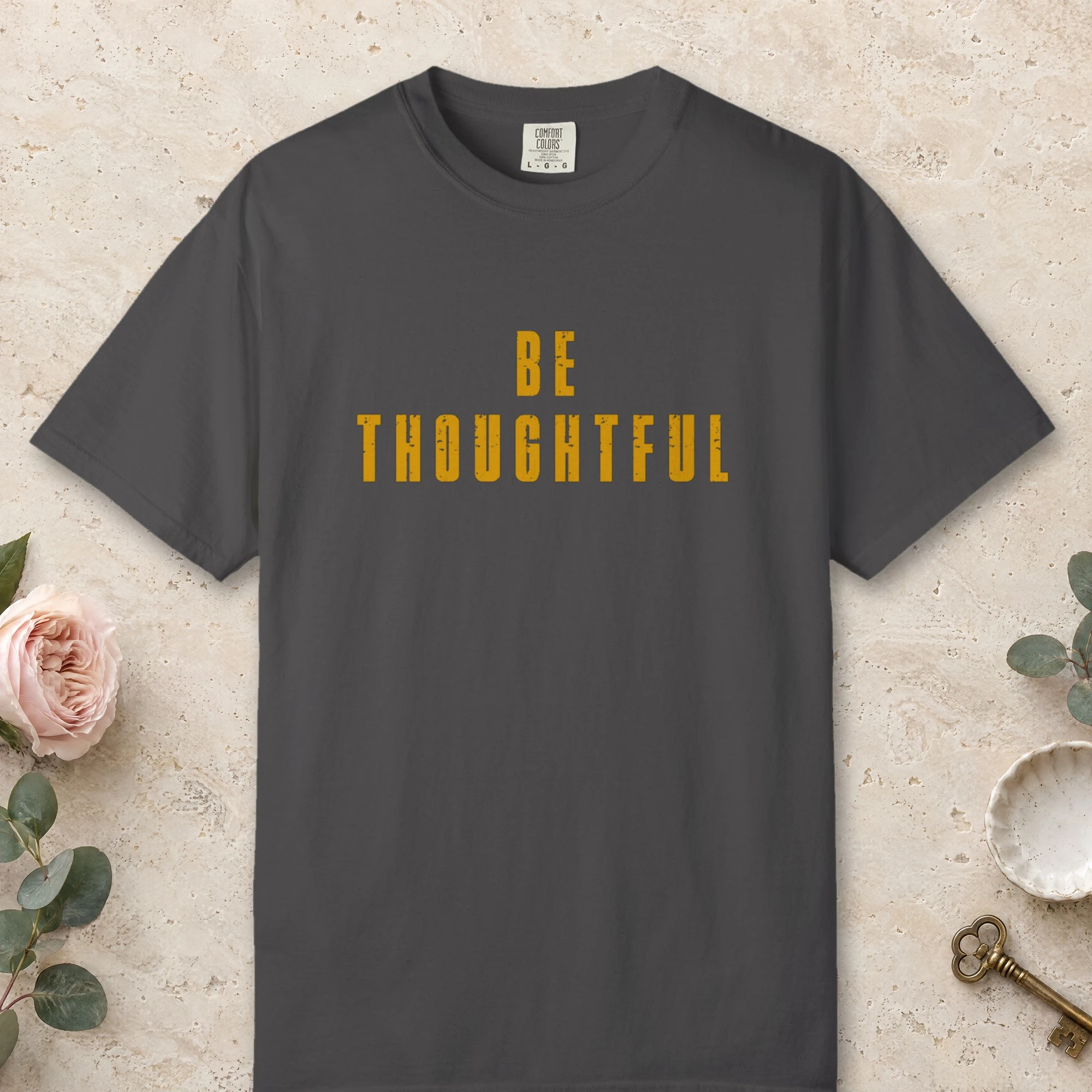 Be Thoughtful design on a Graphite Comfort Colors 1717 tee, laid flat
