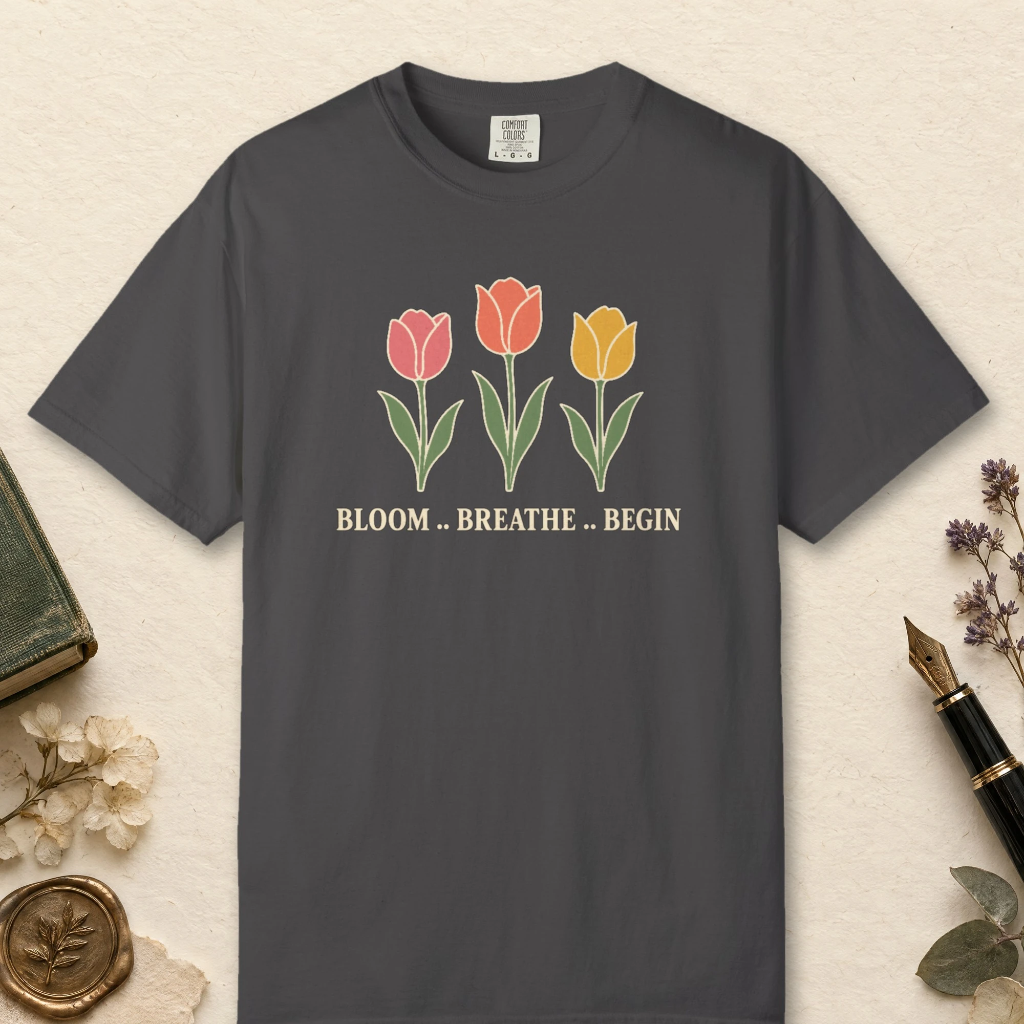 Bloom Breathe Begin design on a Graphite Comfort Colors 1717 tee, laid flat