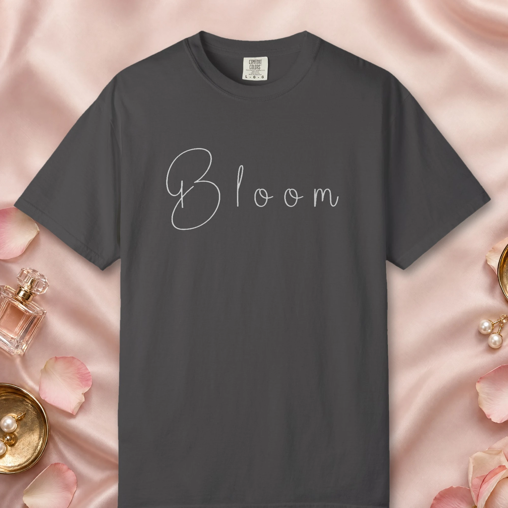 Bloom in Soft Handwriting design on a Graphite Comfort Colors 1717 tee, laid flat