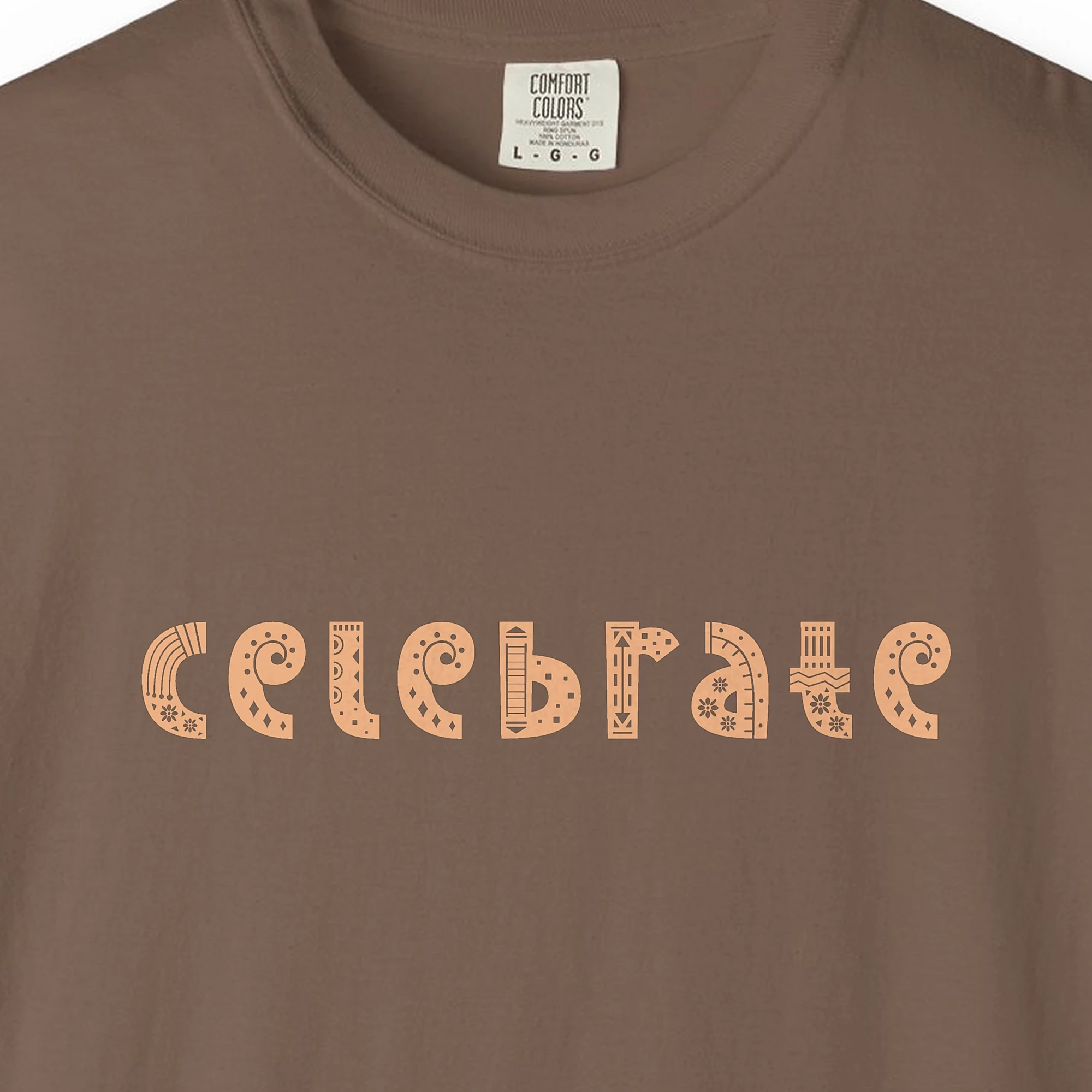 Close-up of the Celebrate print on a Espresso Comfort Colors 1717 tee