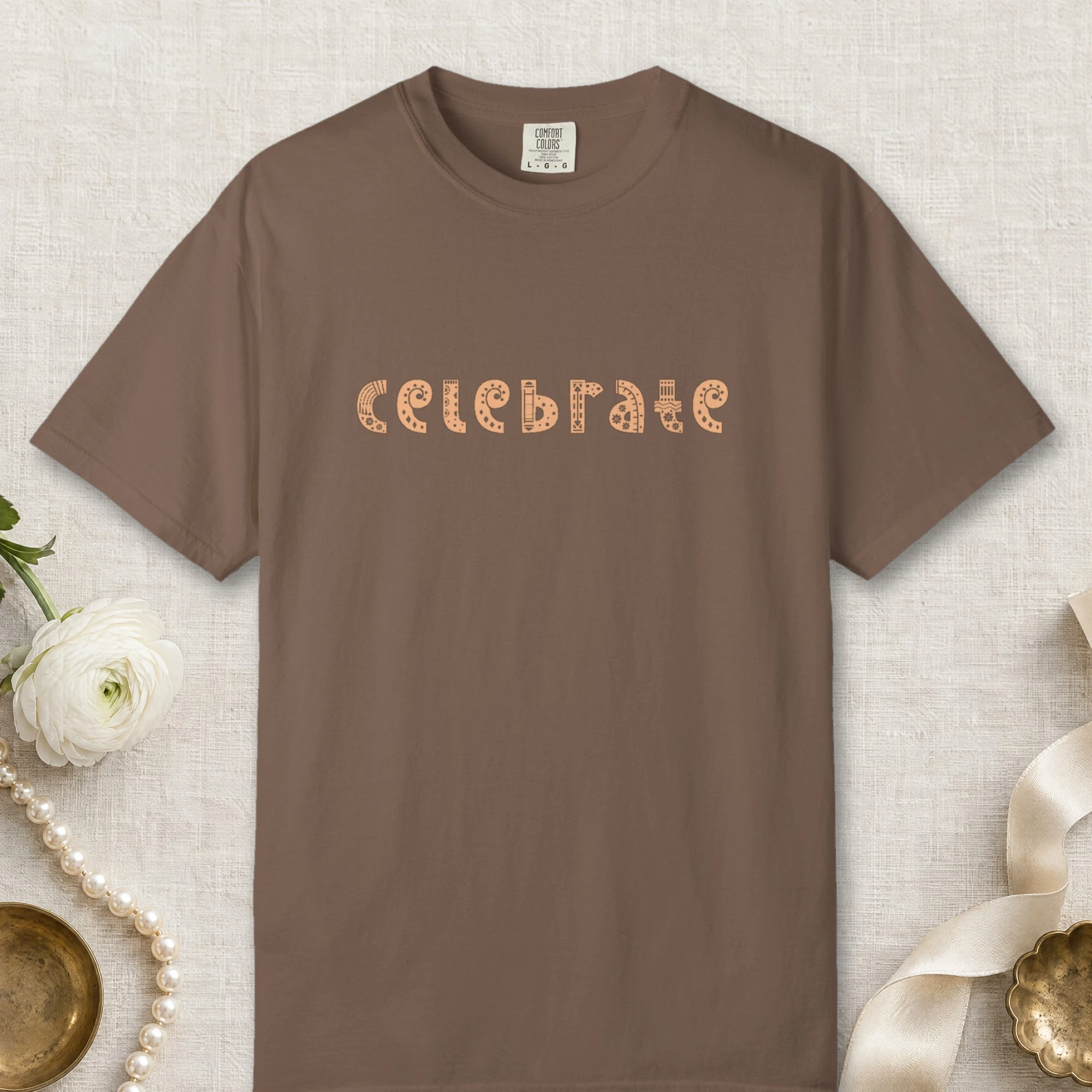 Celebrate design on a Espresso Comfort Colors 1717 tee, laid flat