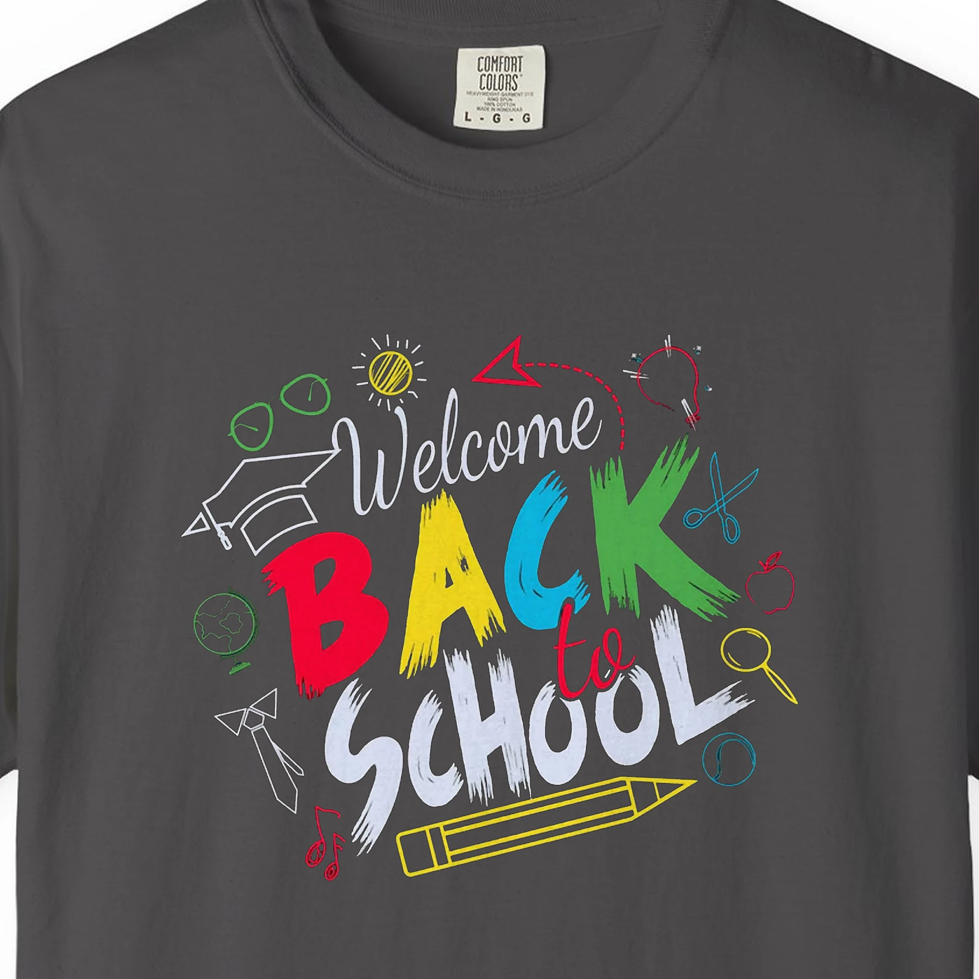 Close-up of the Chalk Doodle Welcome print on a Graphite Comfort Colors 1717 tee