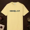 Conquer design on a Butter Comfort Colors 1717 tee, laid flat