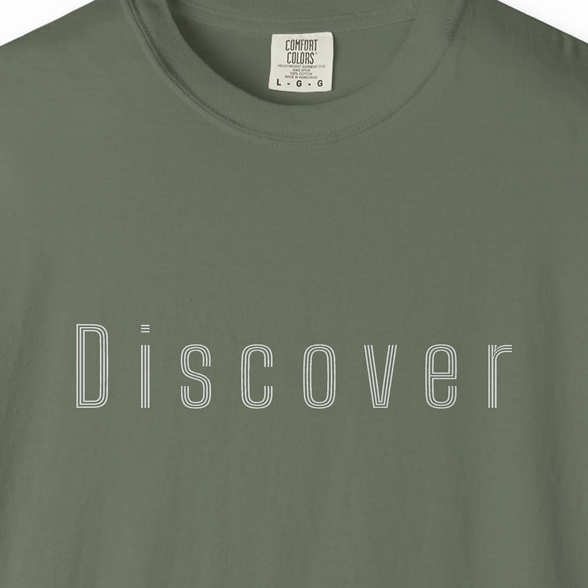 Close-up of the Discover Inline print on a Moss Comfort Colors 1717 tee