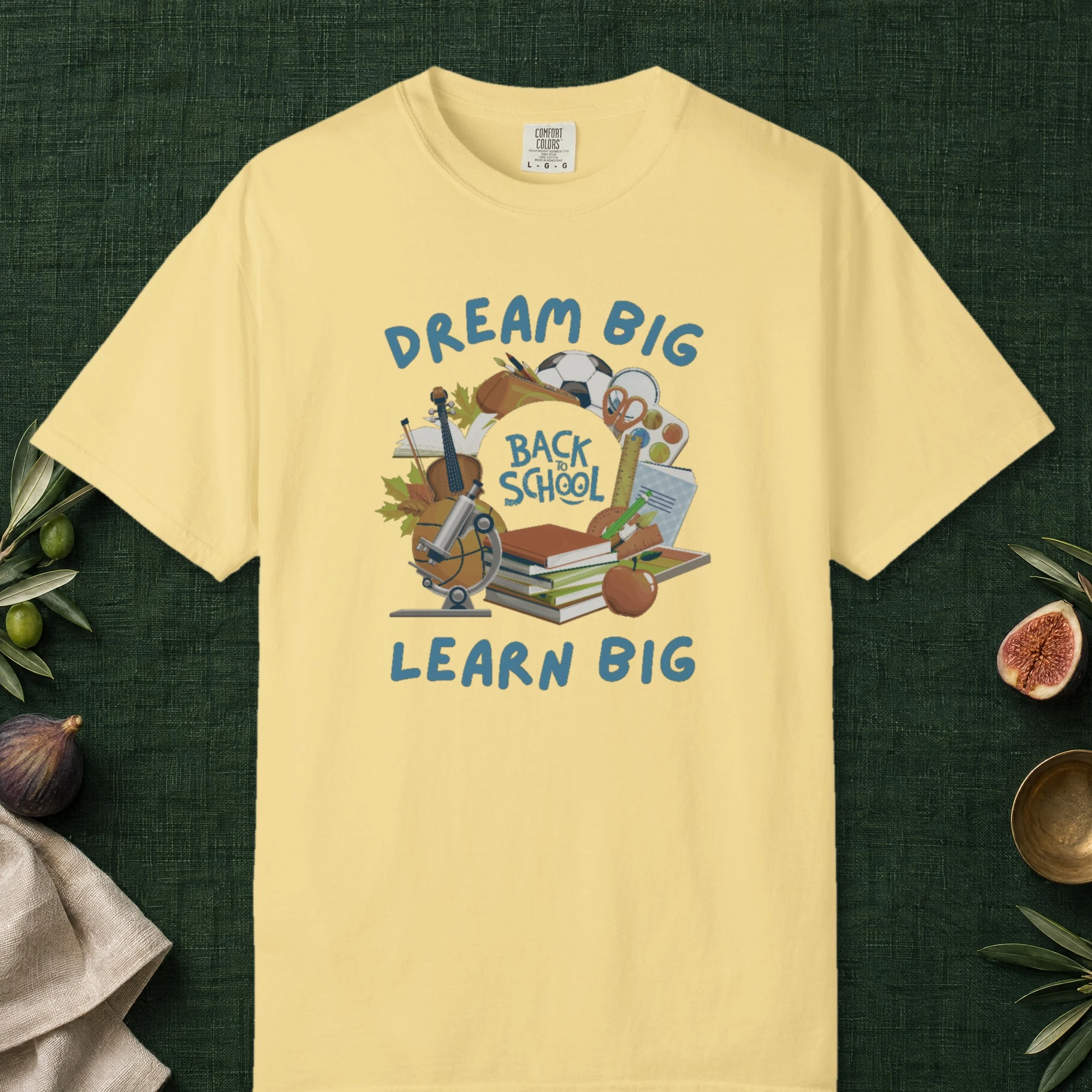 Dream Big Learn Big design on a Butter Comfort Colors 1717 tee, laid flat