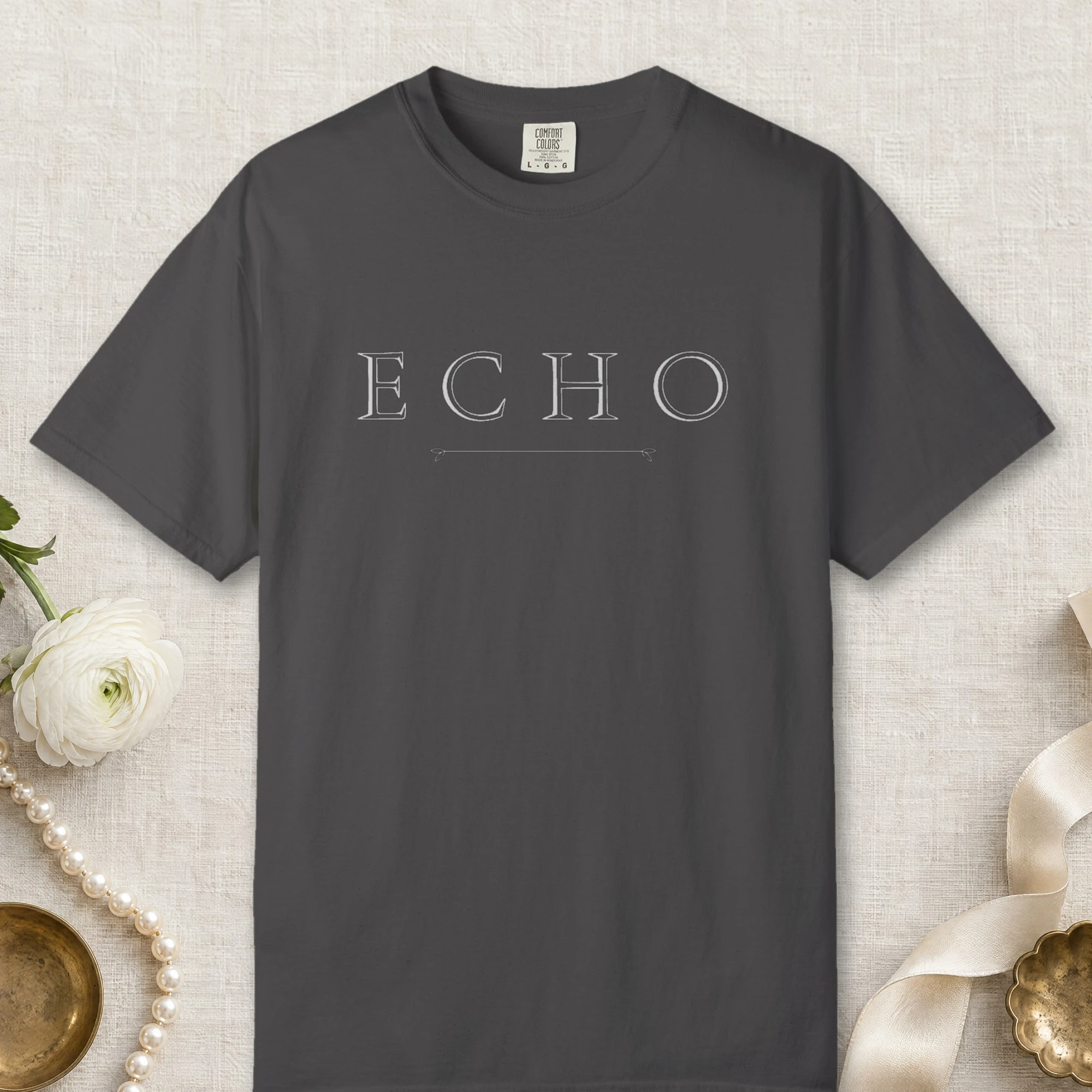Echo Arrow Line design on a Graphite Comfort Colors 1717 tee, laid flat