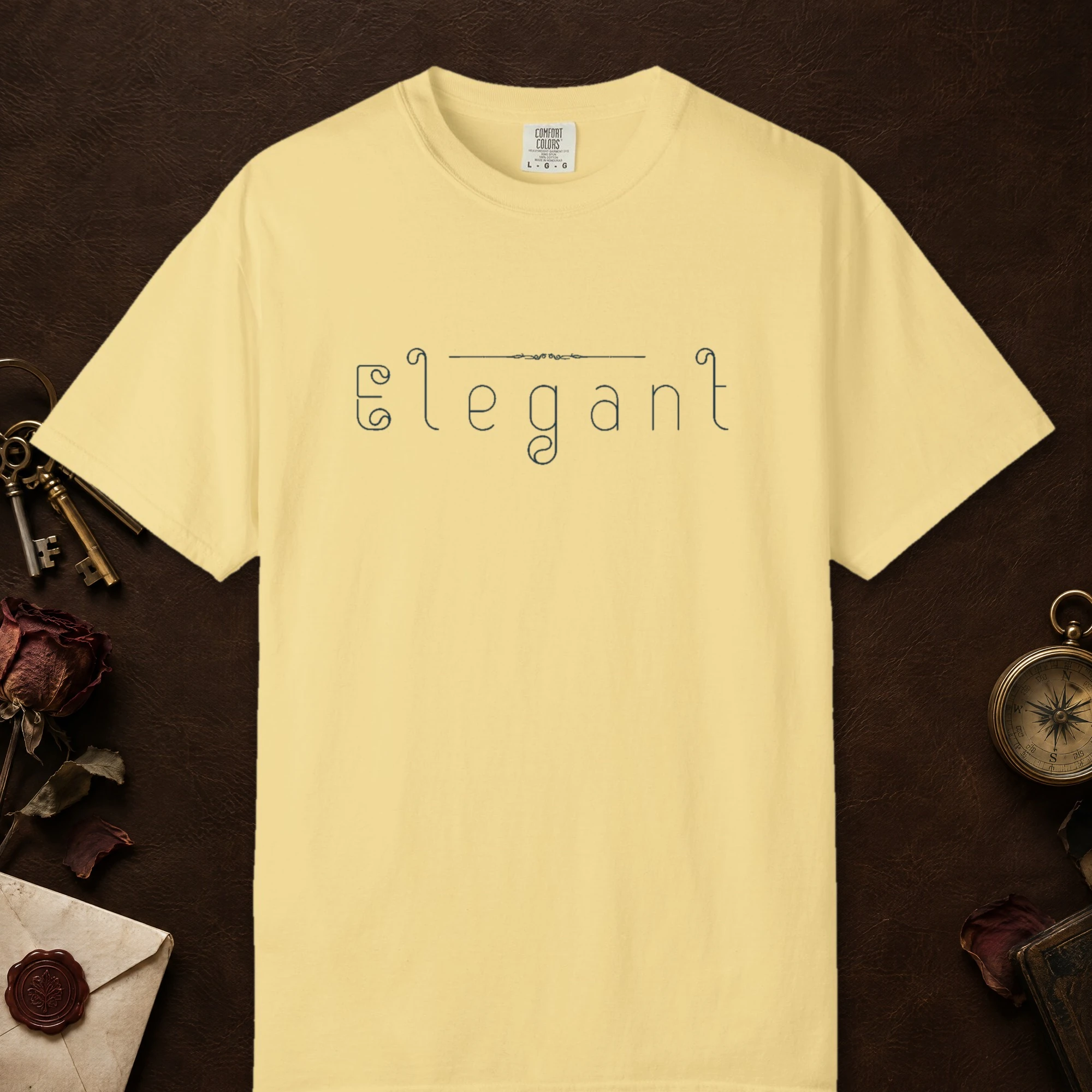 Elegant Outline design on a Butter Comfort Colors 1717 tee, laid flat