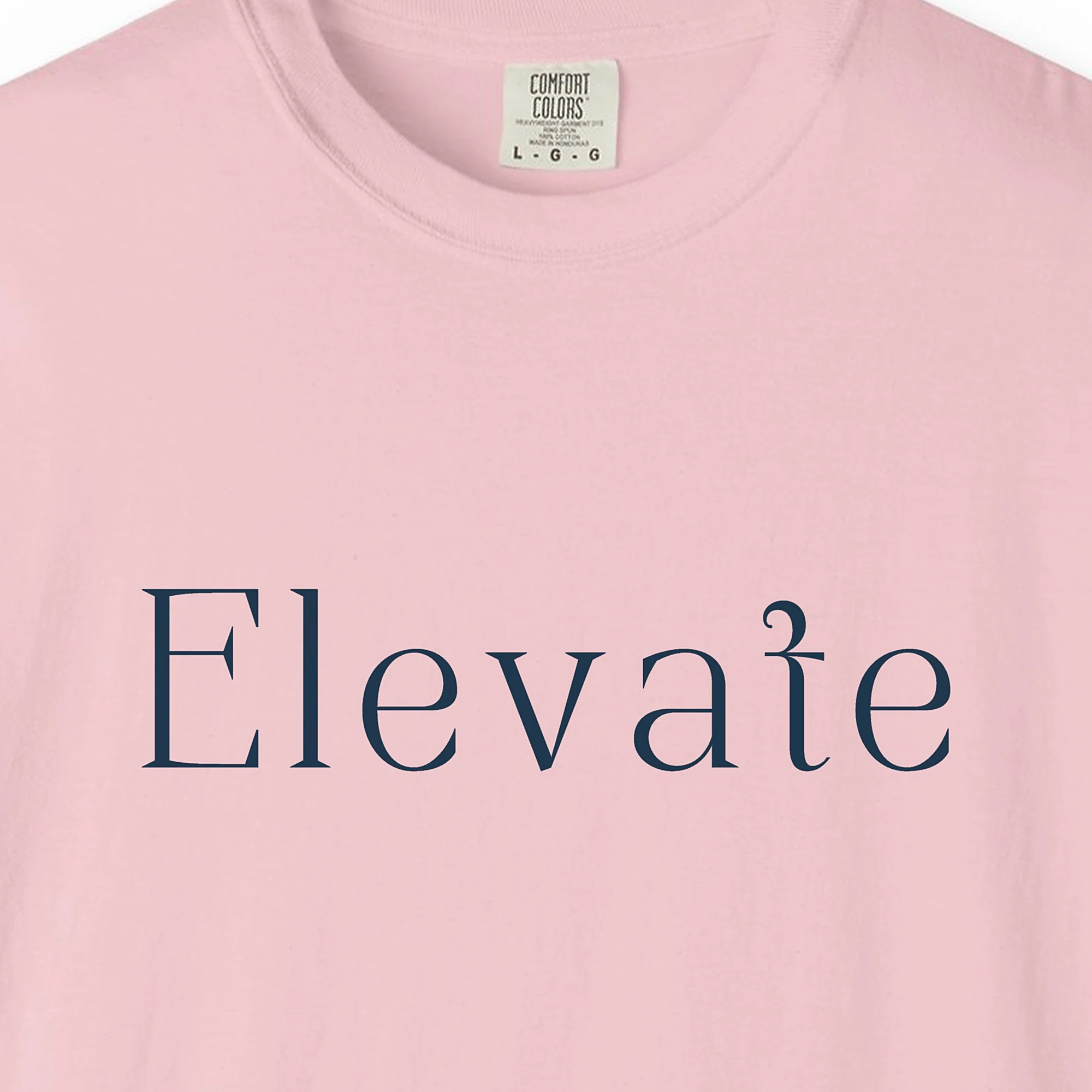 Close-up of the Elevate Serif print on a Blossom Comfort Colors 1717 tee
