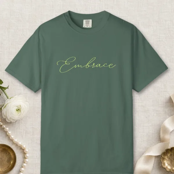 Embrace design on a Blue Spruce Comfort Colors 1717 tee, laid flat