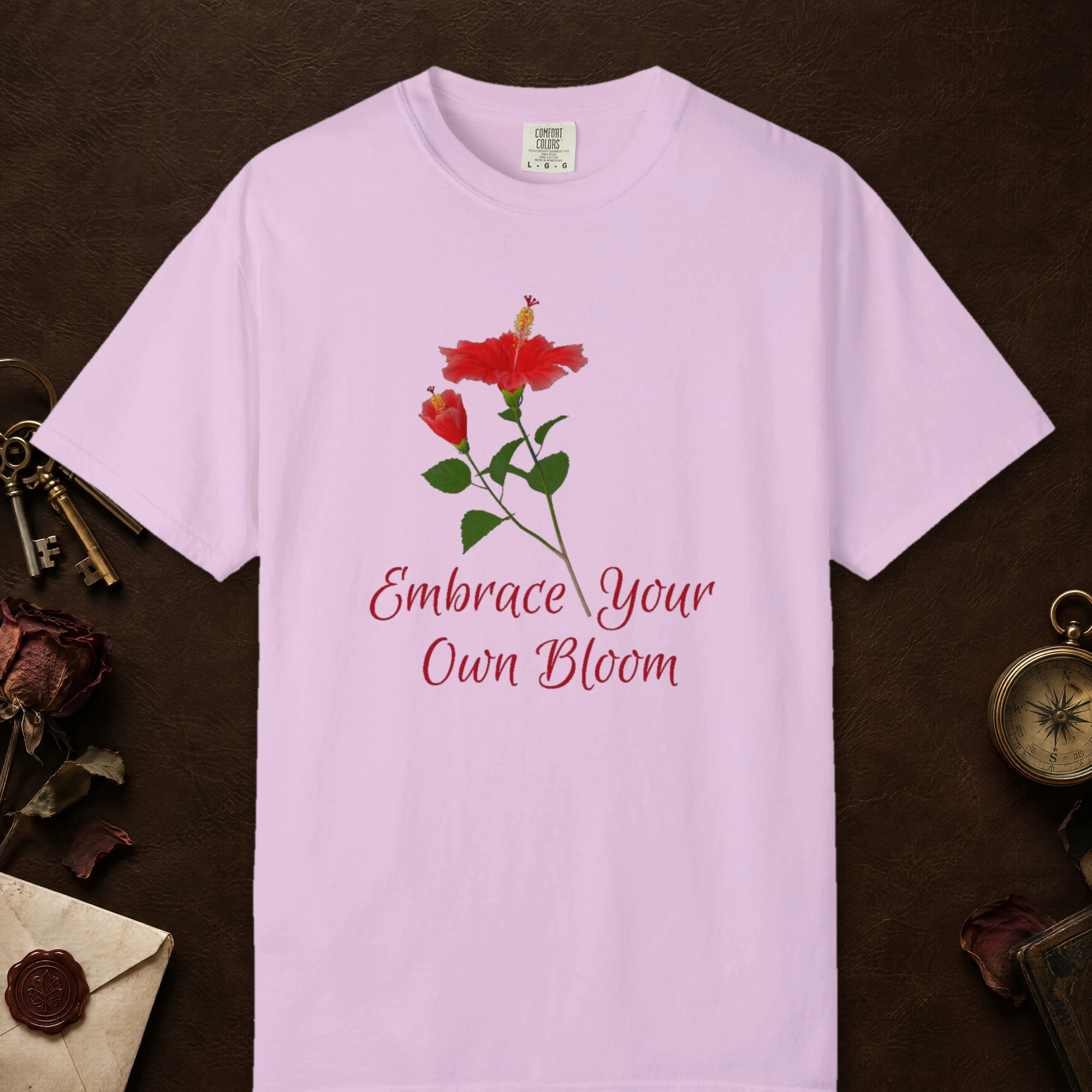 Embrace Your Own Bloom design on a Orchid Comfort Colors 1717 tee, laid flat