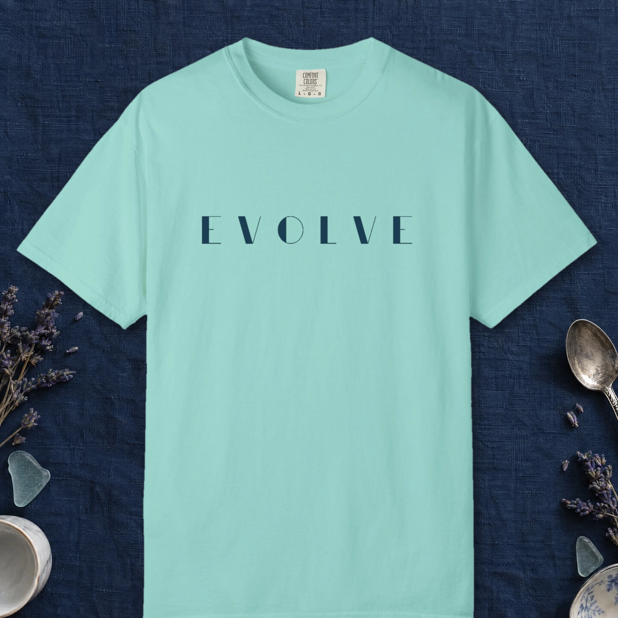 Evolve Art Deco design on a Chalky Mint Comfort Colors 1717 tee, laid flat