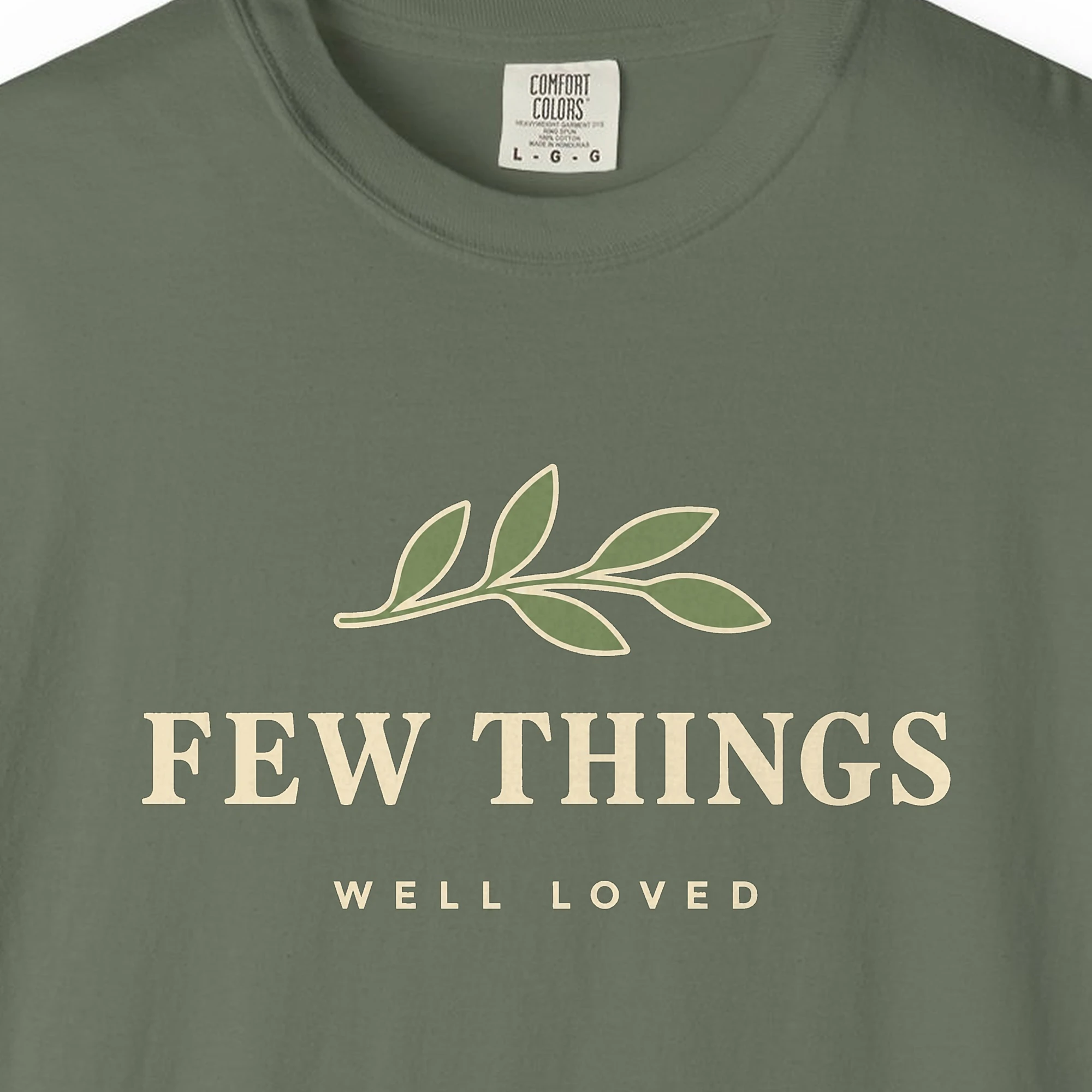 few-things-well-loved-tee-moss-chest Close-up of the Few Things Well Loved print on a Moss Comfort Colors 1717 tee