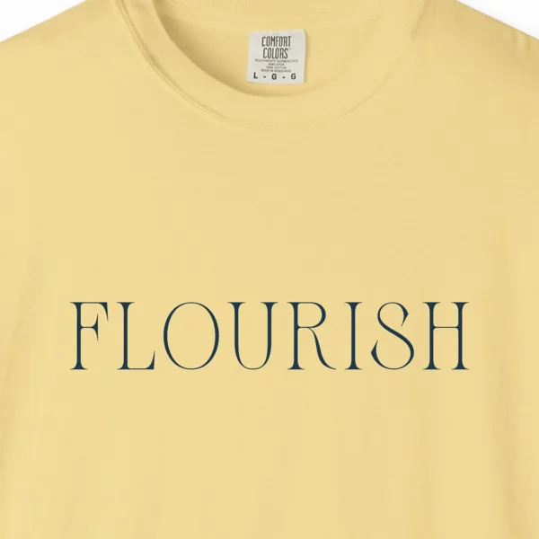 Close-up of the Flourish Tall Serif print on a Butter Comfort Colors 1717 tee