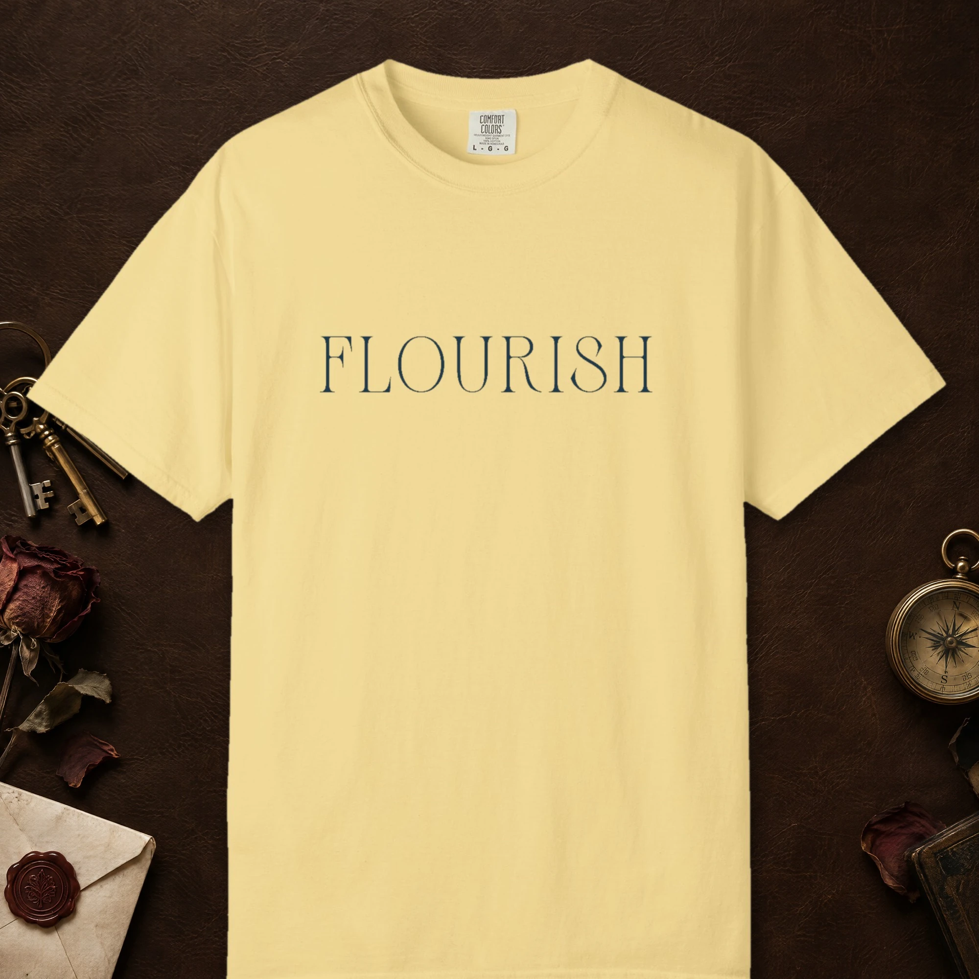Flourish Tall Serif design on a Butter Comfort Colors 1717 tee, laid flat