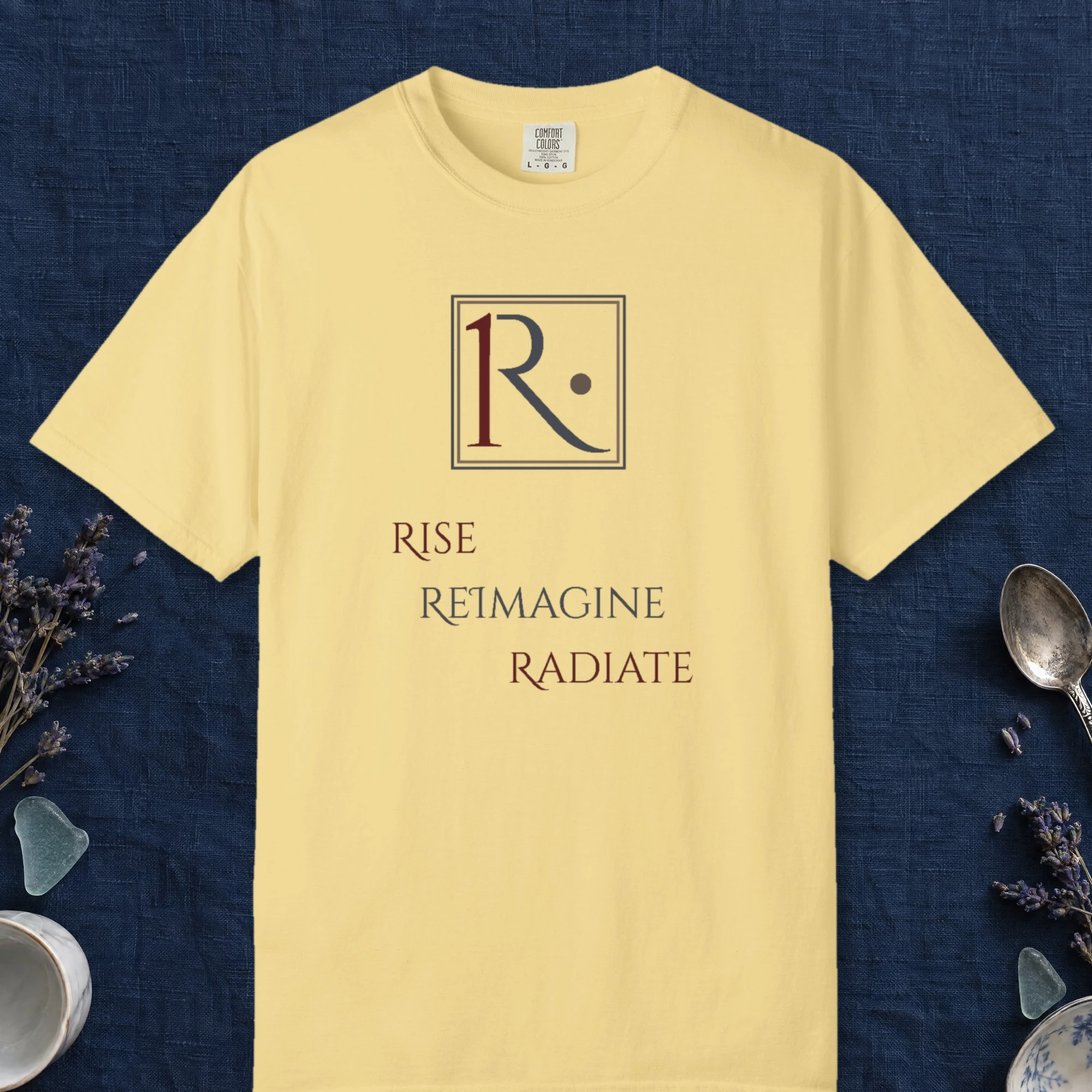 Framed R Monogram design on a Butter Comfort Colors 1717 tee, laid flat