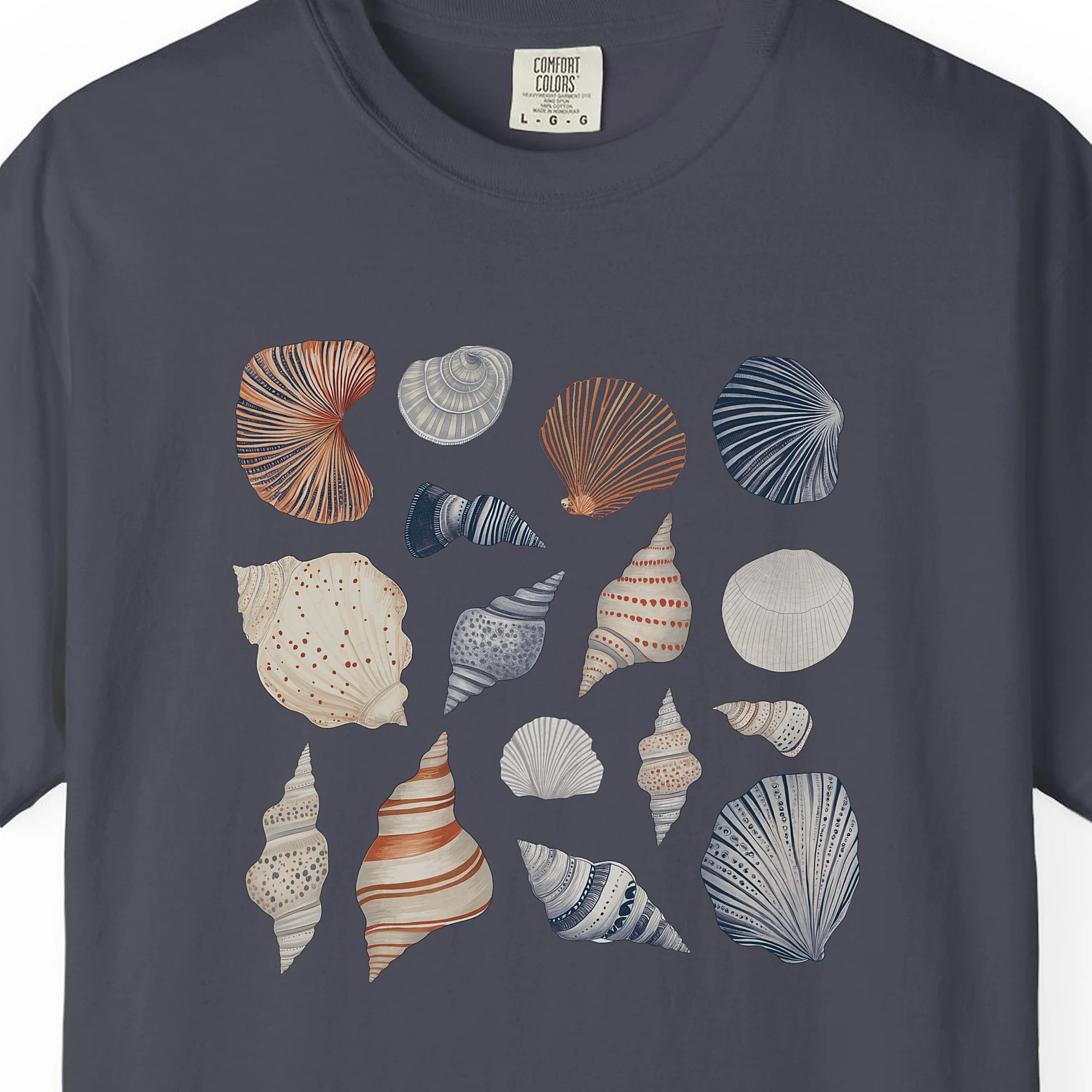 Close-up of the Gathered Seashells print on a Navy Comfort Colors 1717 tee
