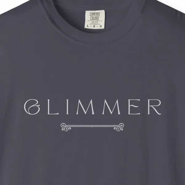 Close-up of the Glimmer Scroll print on a Navy Comfort Colors 1717 tee