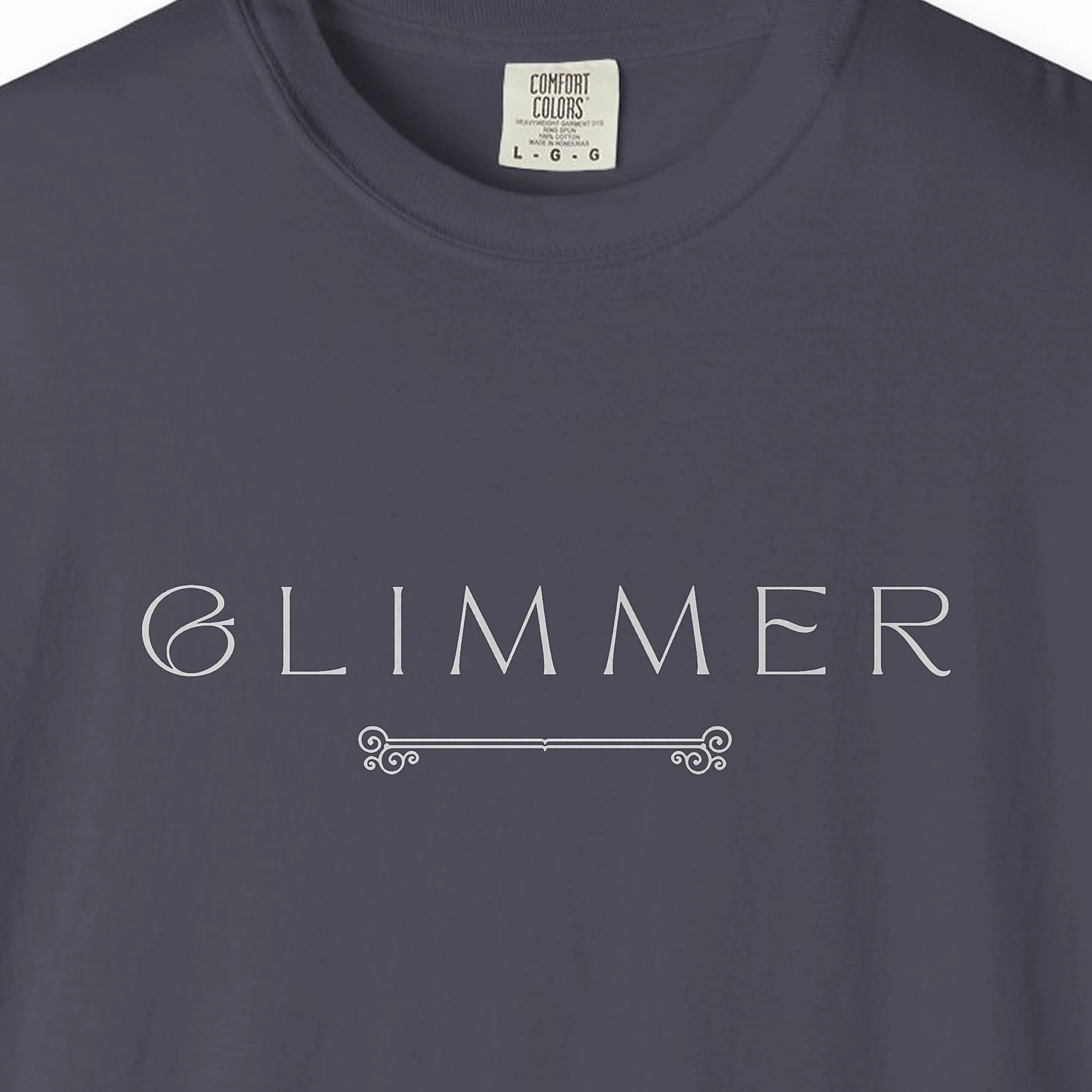 Close-up of the Glimmer Scroll print on a Navy Comfort Colors 1717 tee