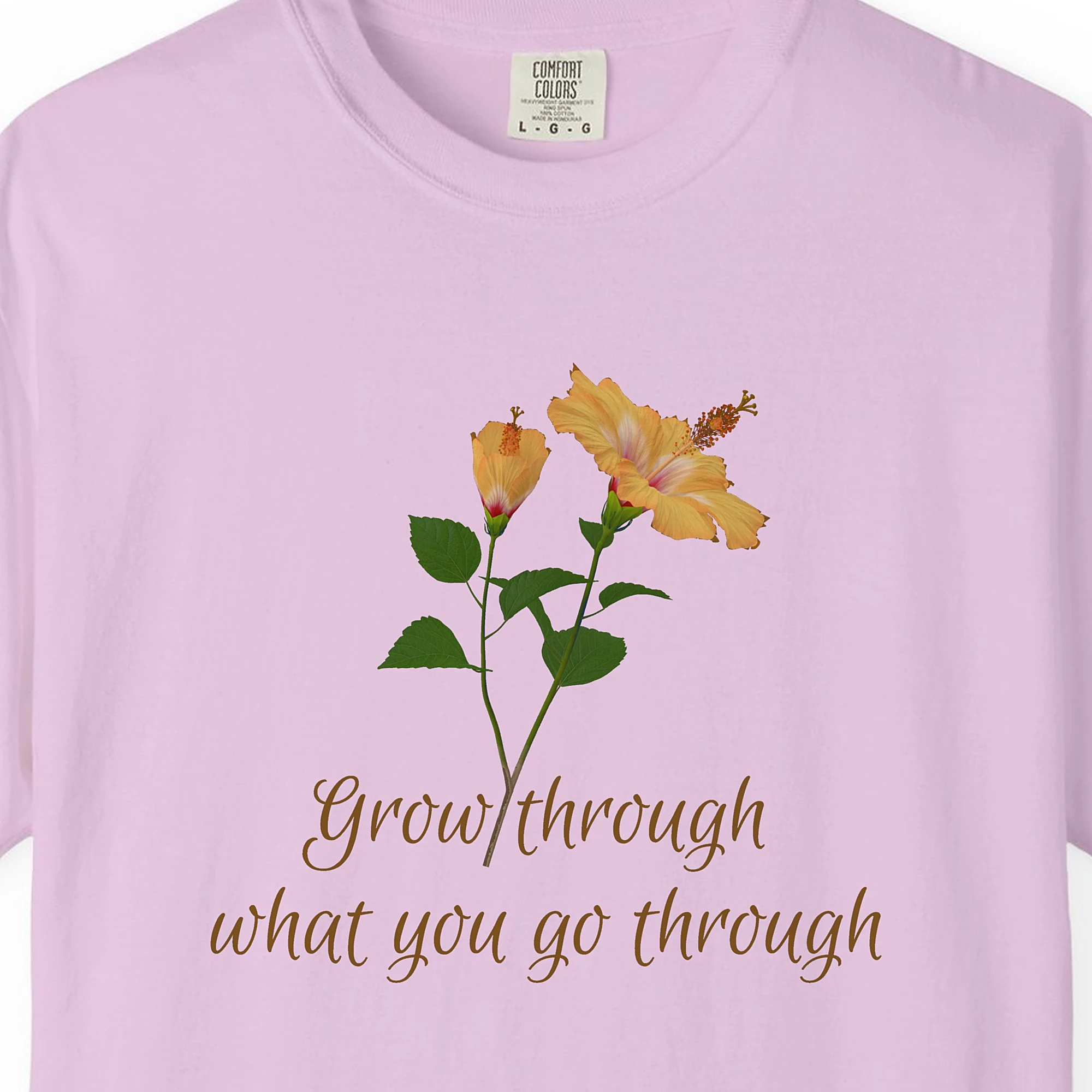 Close-up of the Grow Through It print on a Orchid Comfort Colors 1717 tee