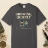 Growing Quietly design on a Graphite Comfort Colors 1717 tee, laid flat