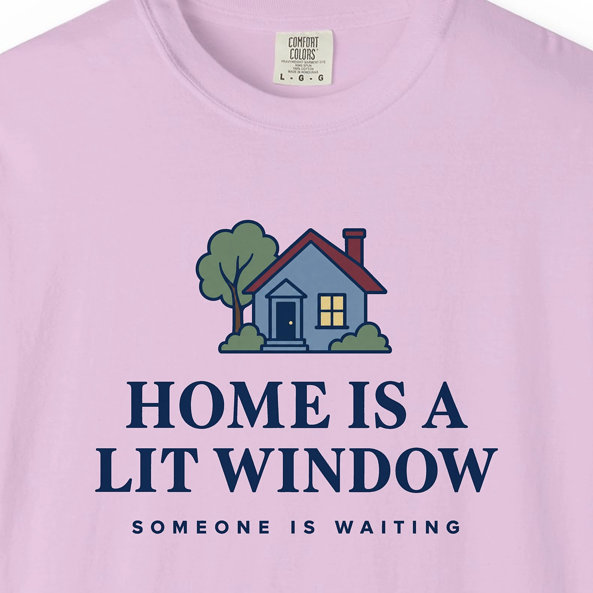 Close-up of the Home Is a Lit Window print on a Orchid Comfort Colors 1717 tee