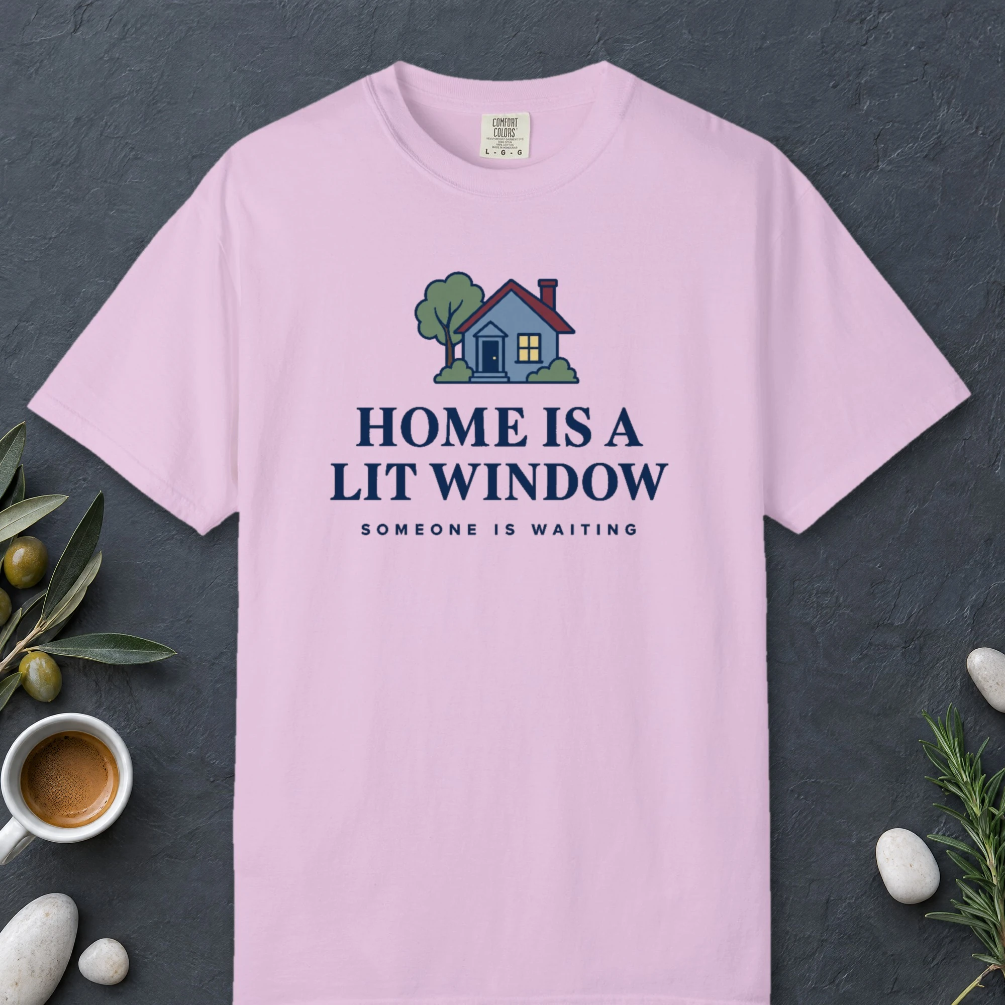Home Is a Lit Window design on a Orchid Comfort Colors 1717 tee, laid flat
