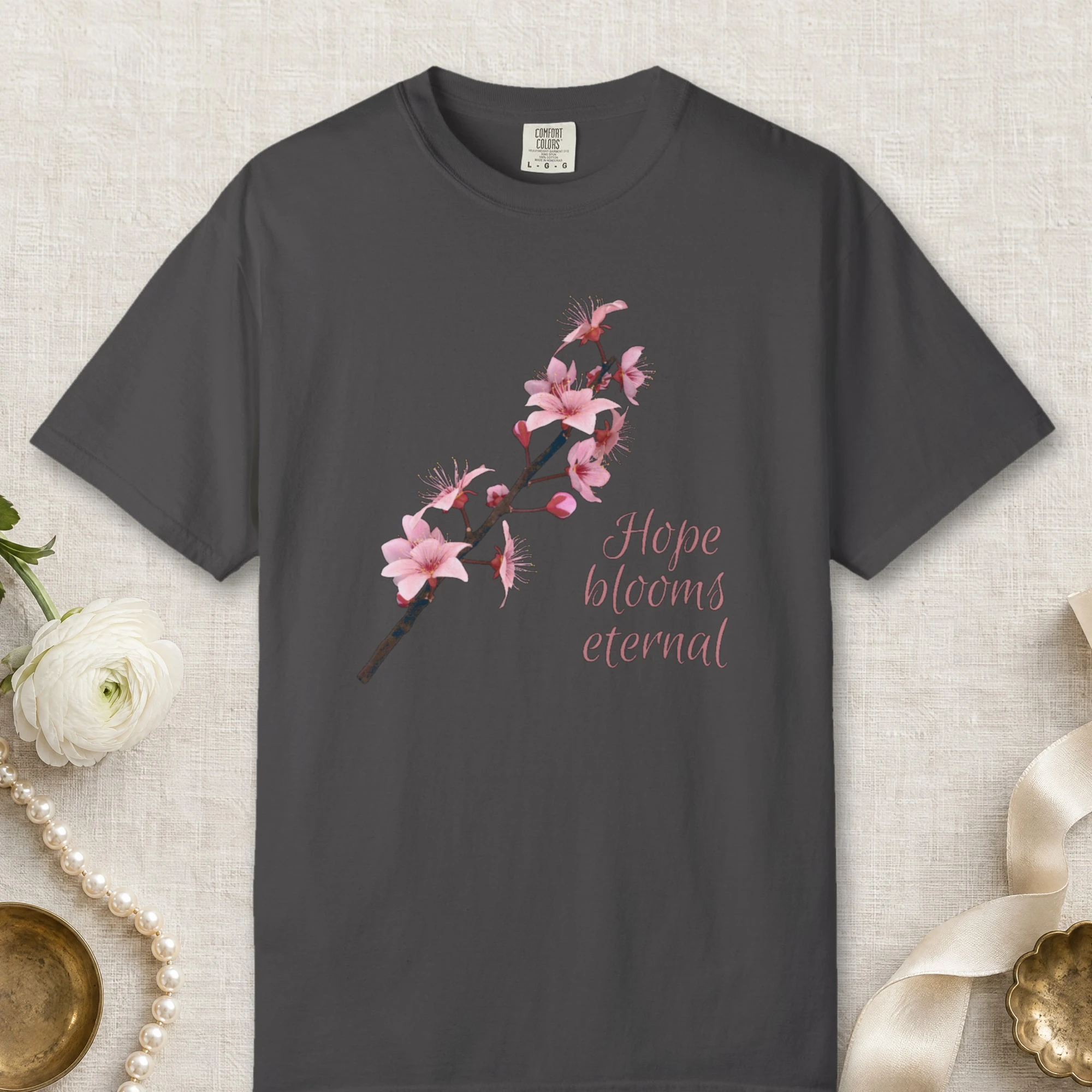 Hope Blooms Eternal design on a Graphite Comfort Colors 1717 tee, laid flat