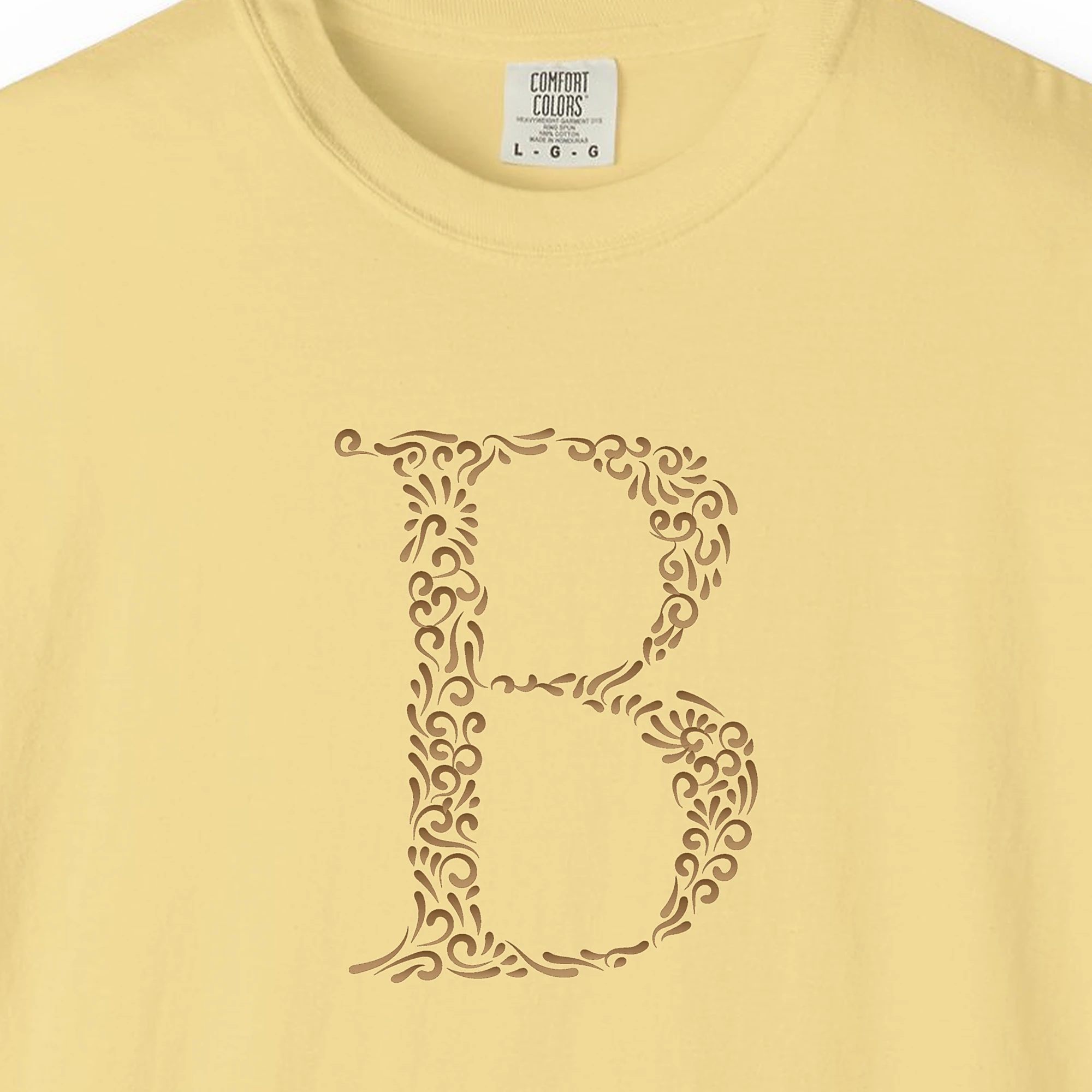 Close-up of the Initial B print on a Butter Comfort Colors 1717 tee