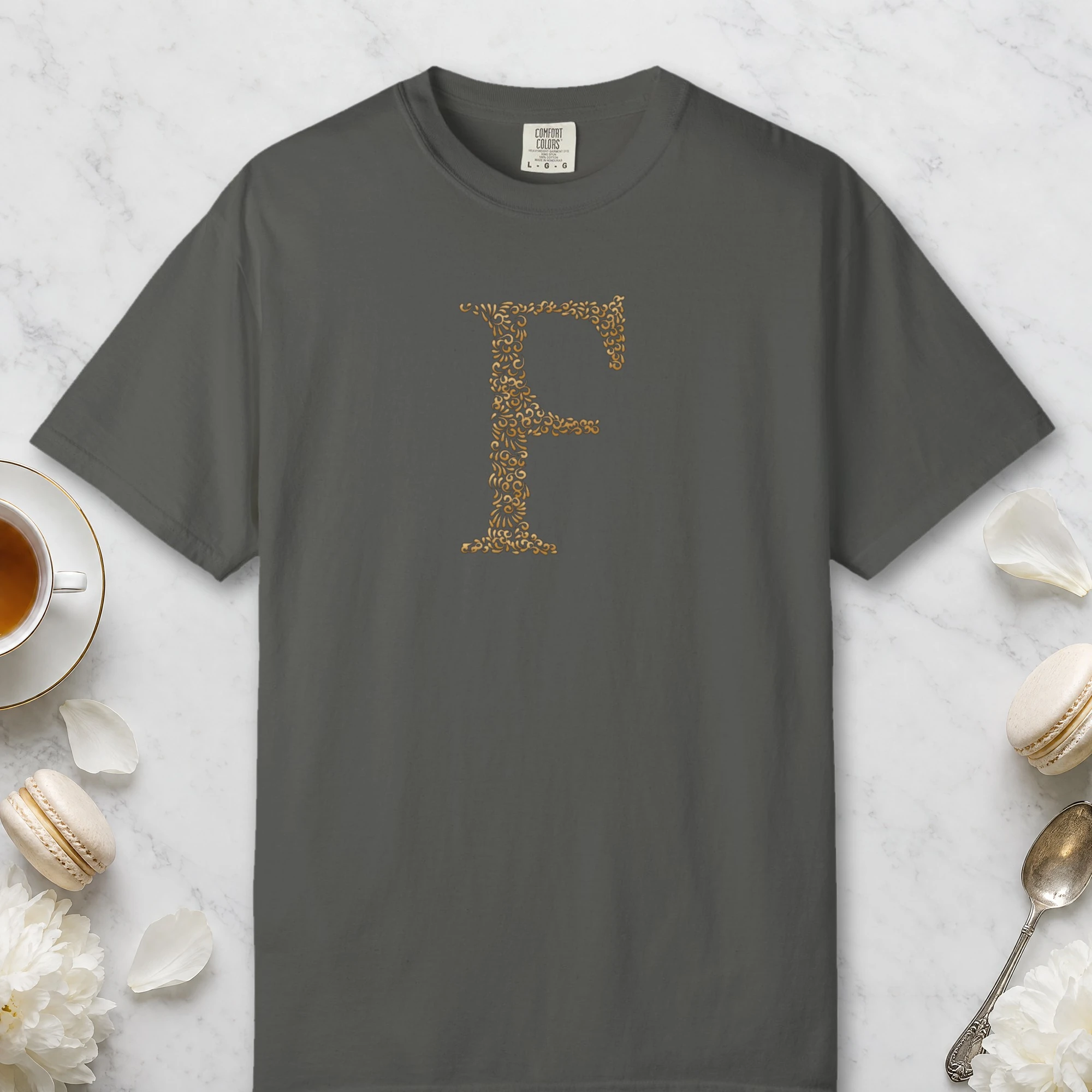 Initial F design on a Pepper Comfort Colors 1717 tee, laid flat