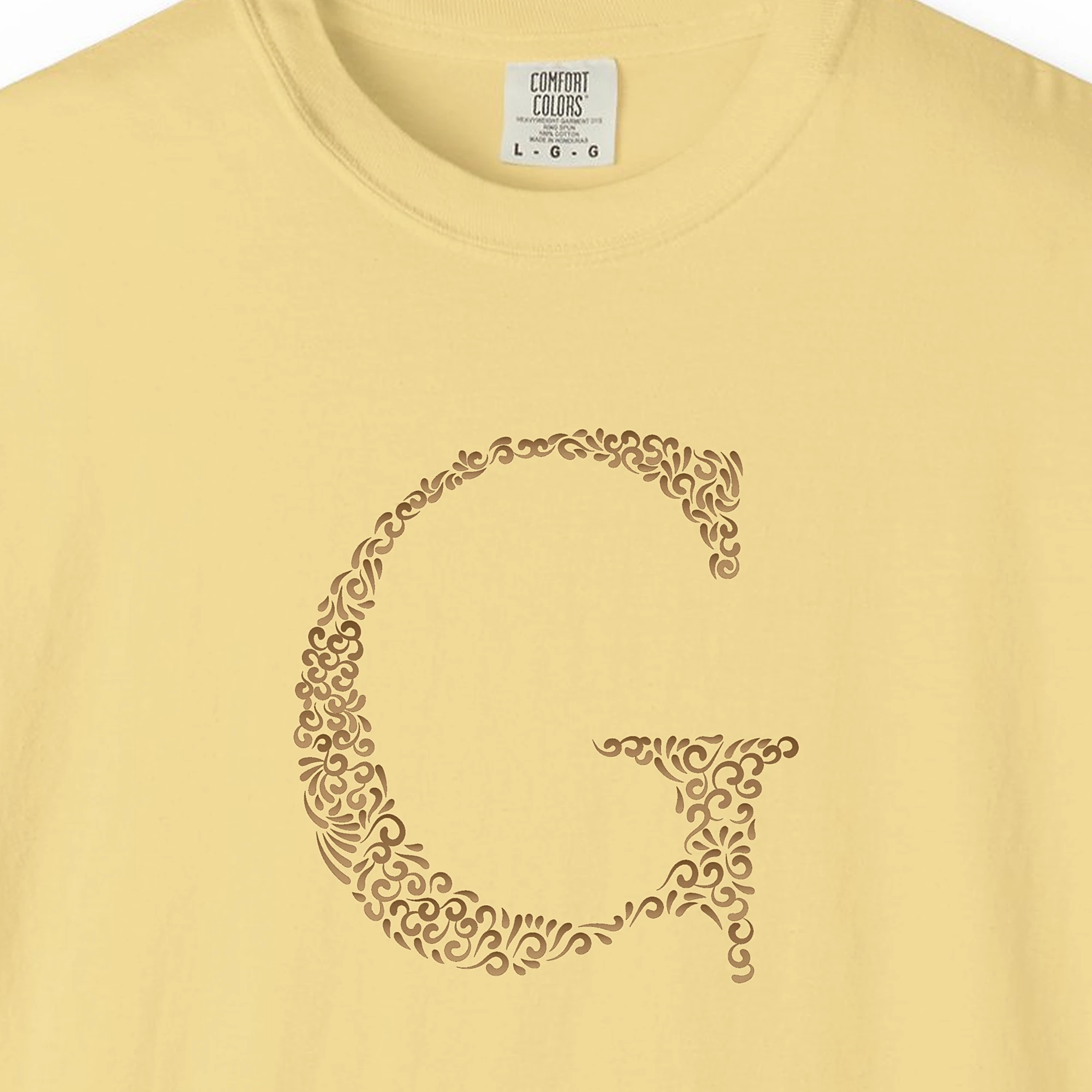Close-up of the Initial G print on a Butter Comfort Colors 1717 tee