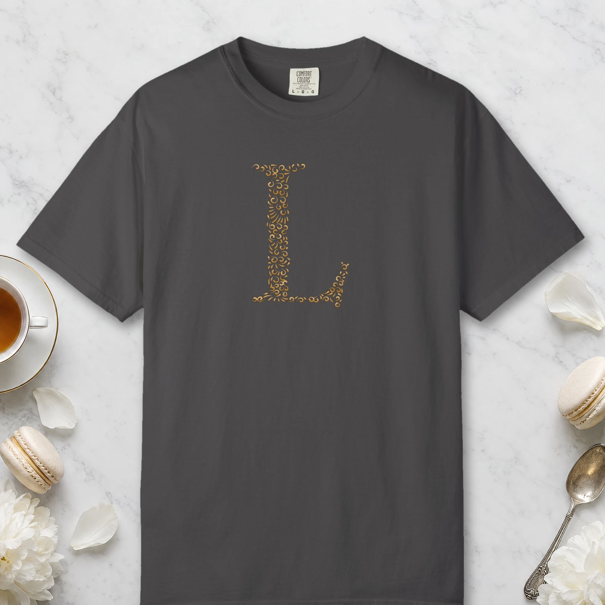Initial L design on a Graphite Comfort Colors 1717 tee, laid flat