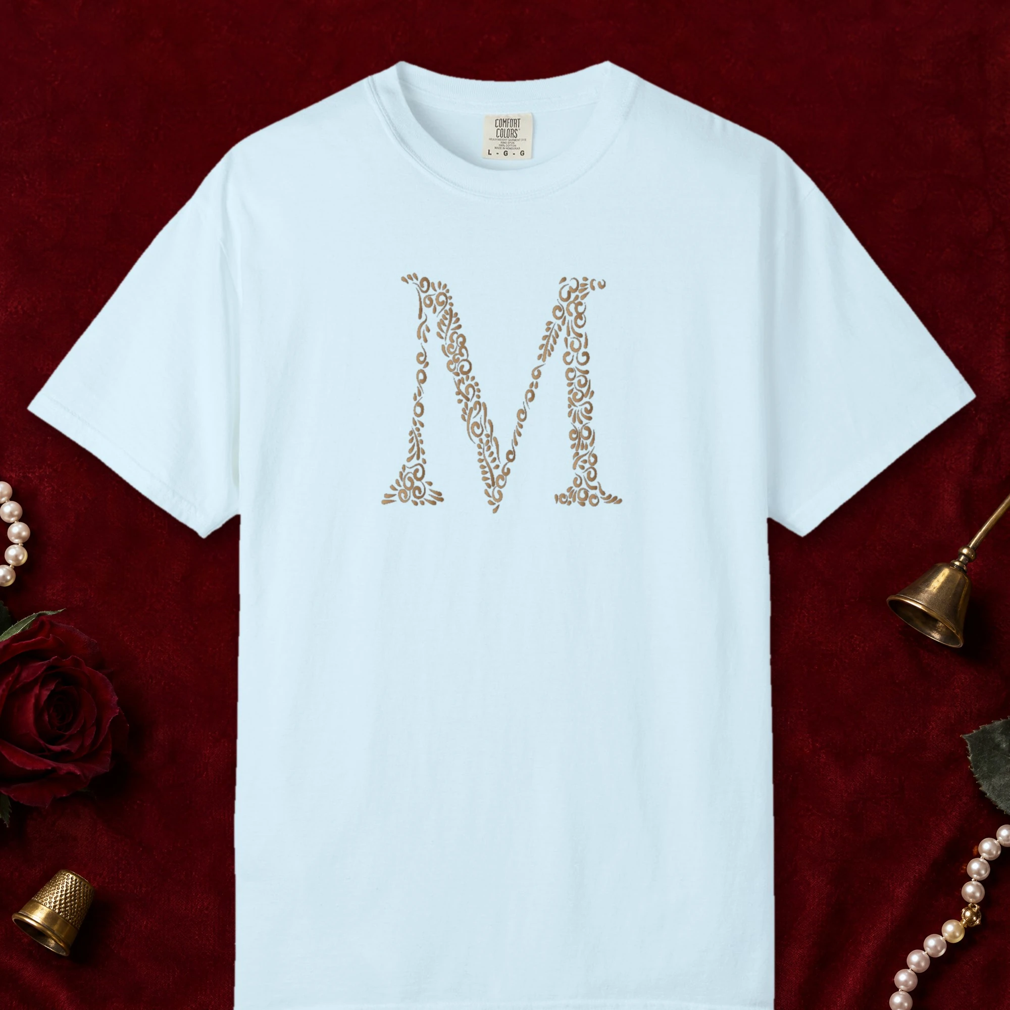 Initial M design on a Chambray Comfort Colors 1717 tee, laid flat