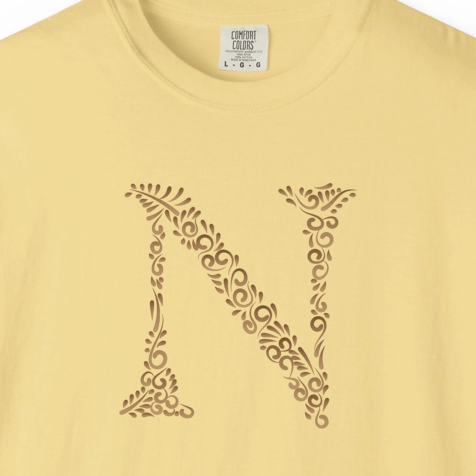 Close-up of the Initial N print on a Butter Comfort Colors 1717 tee