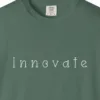 innovate-curled-serif-tee-blue-spruce-chest Close-up of the Innovate Curled Serif print on a Blue Spruce Comfort Colors 1717 tee