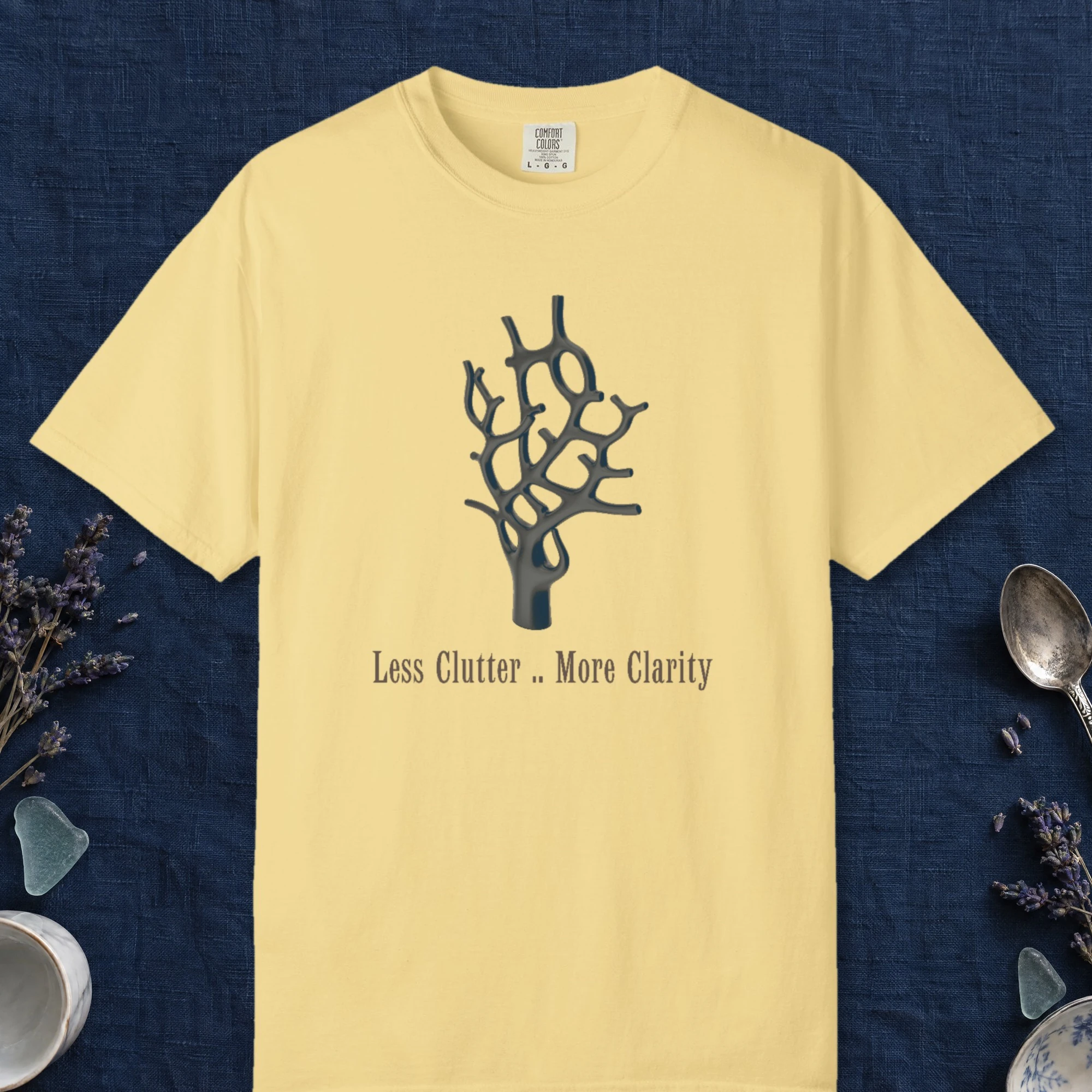Less Clutter More Clarity design on a Butter Comfort Colors 1717 tee, laid flat