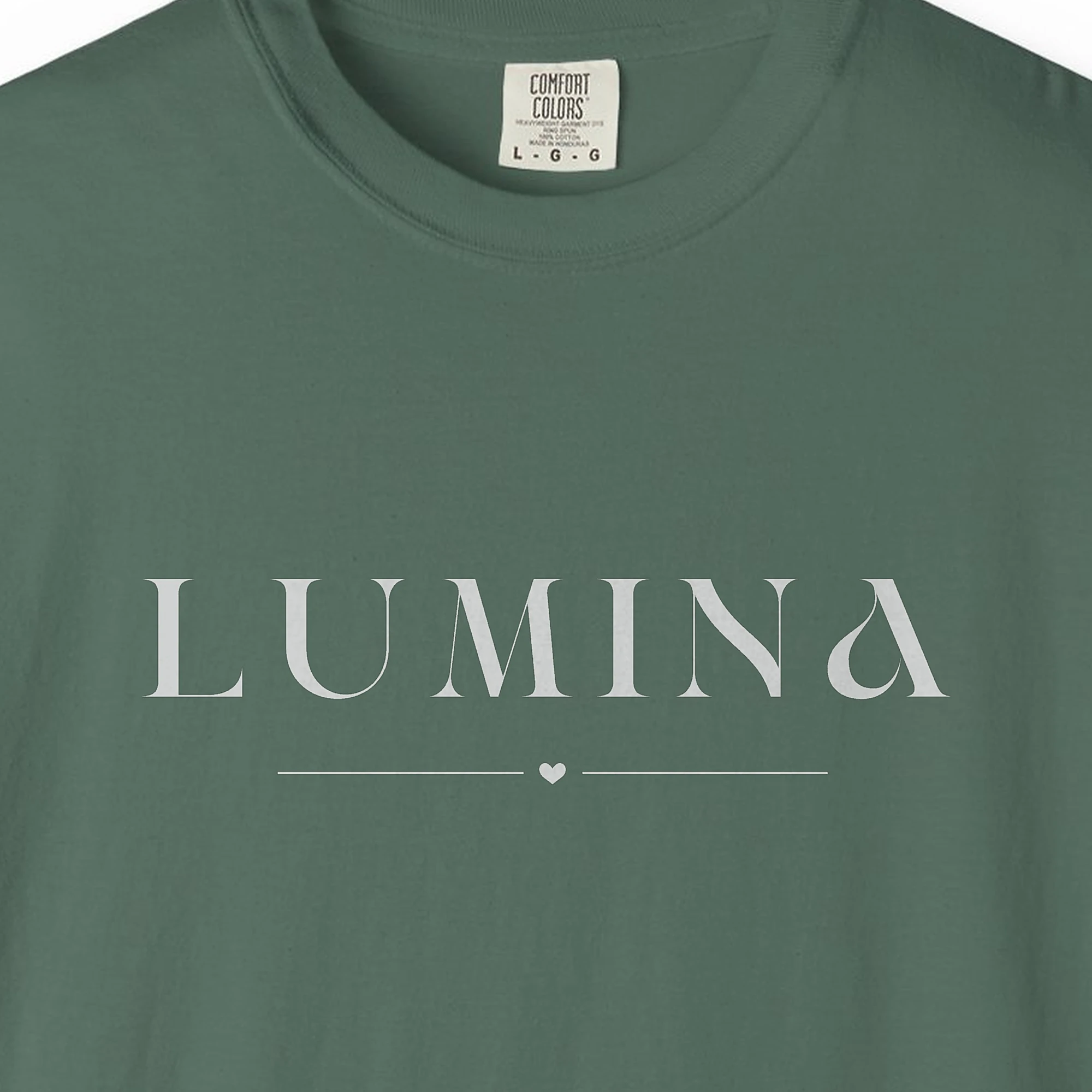 Close-up of the Lumina Little Heart print on a Blue Spruce Comfort Colors 1717 tee