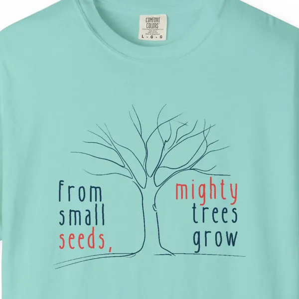Close-up of the Mighty Trees Grow print on a Chalky Mint Comfort Colors 1717 tee