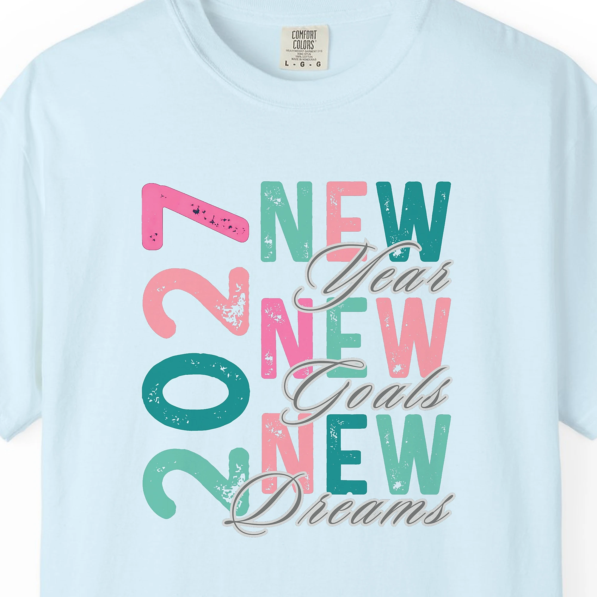 Close-up of the New Goals New Dreams print on a Chambray Comfort Colors 1717 tee