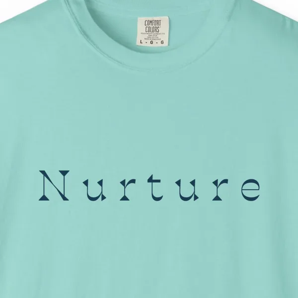 Close-up of the Nurture Flared Serif print on a Chalky Mint Comfort Colors 1717 tee