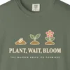 Close-up of the Plant Wait Bloom print on a Moss Comfort Colors 1717 tee