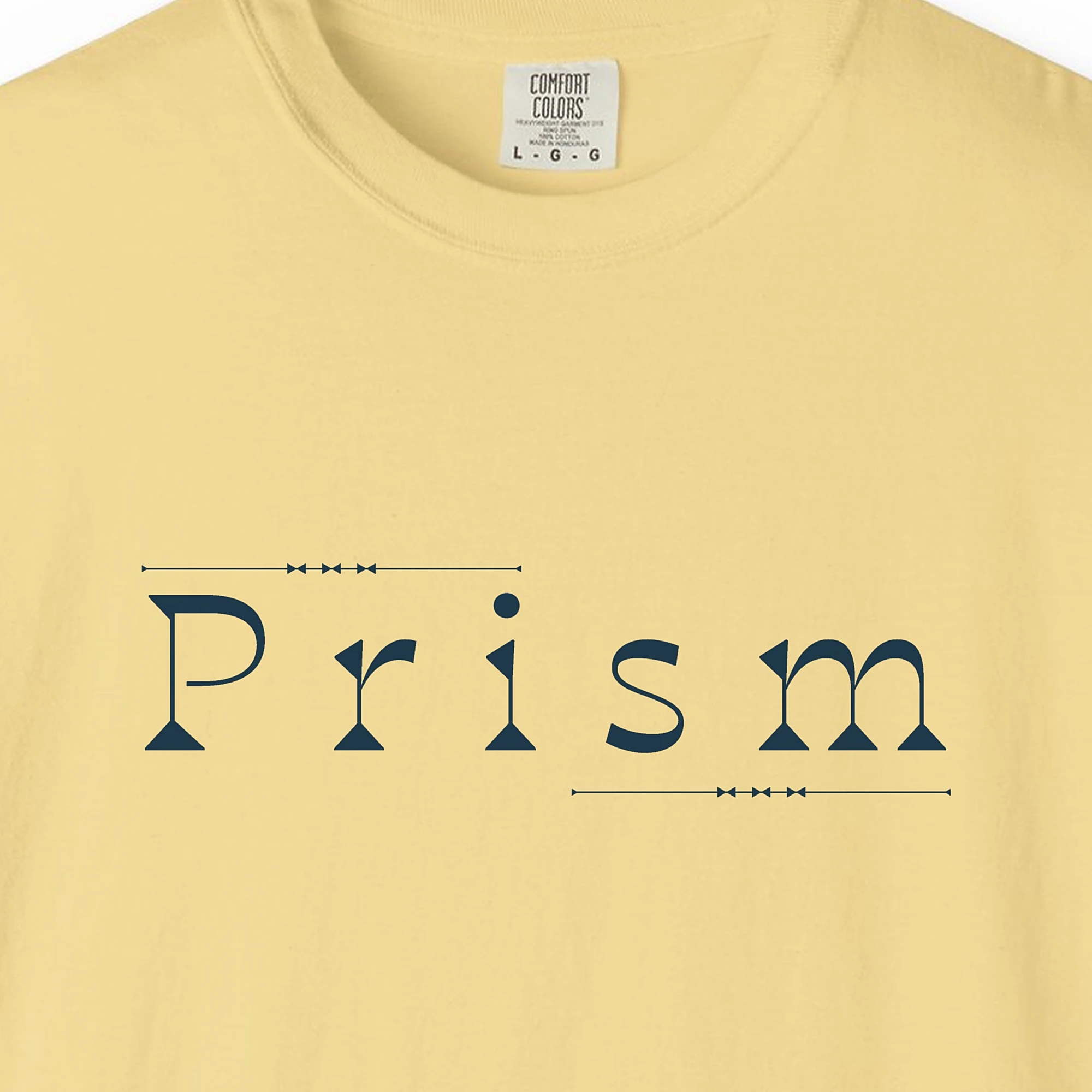 Close-up of the Prism Slab Serif print on a Butter Comfort Colors 1717 tee